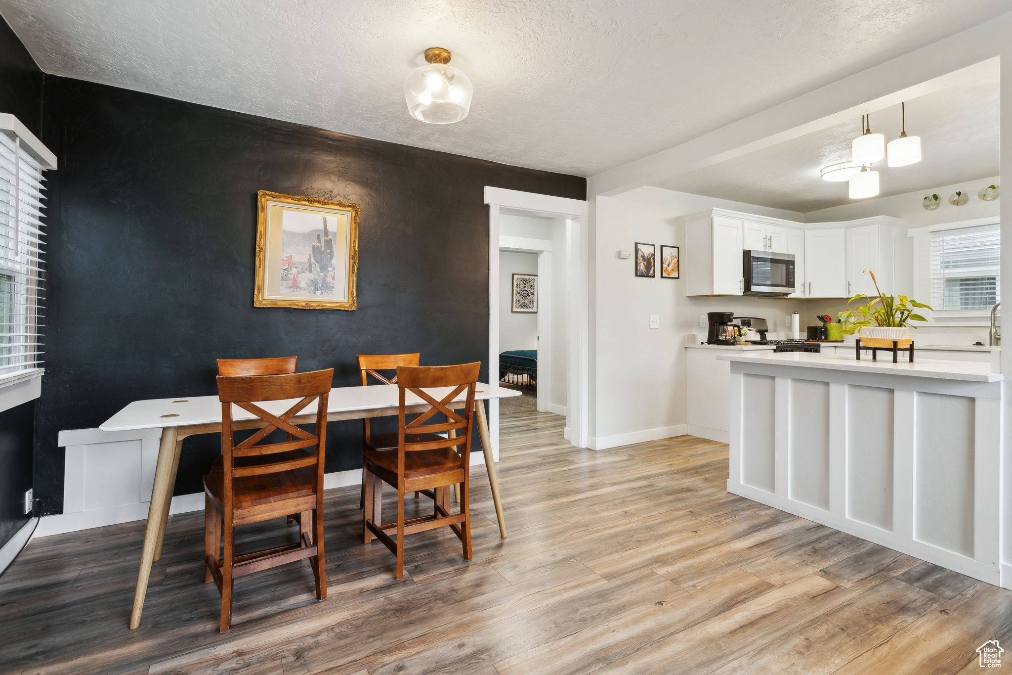 Dining area with light hardwood / wood-style floors and a textured ceiling