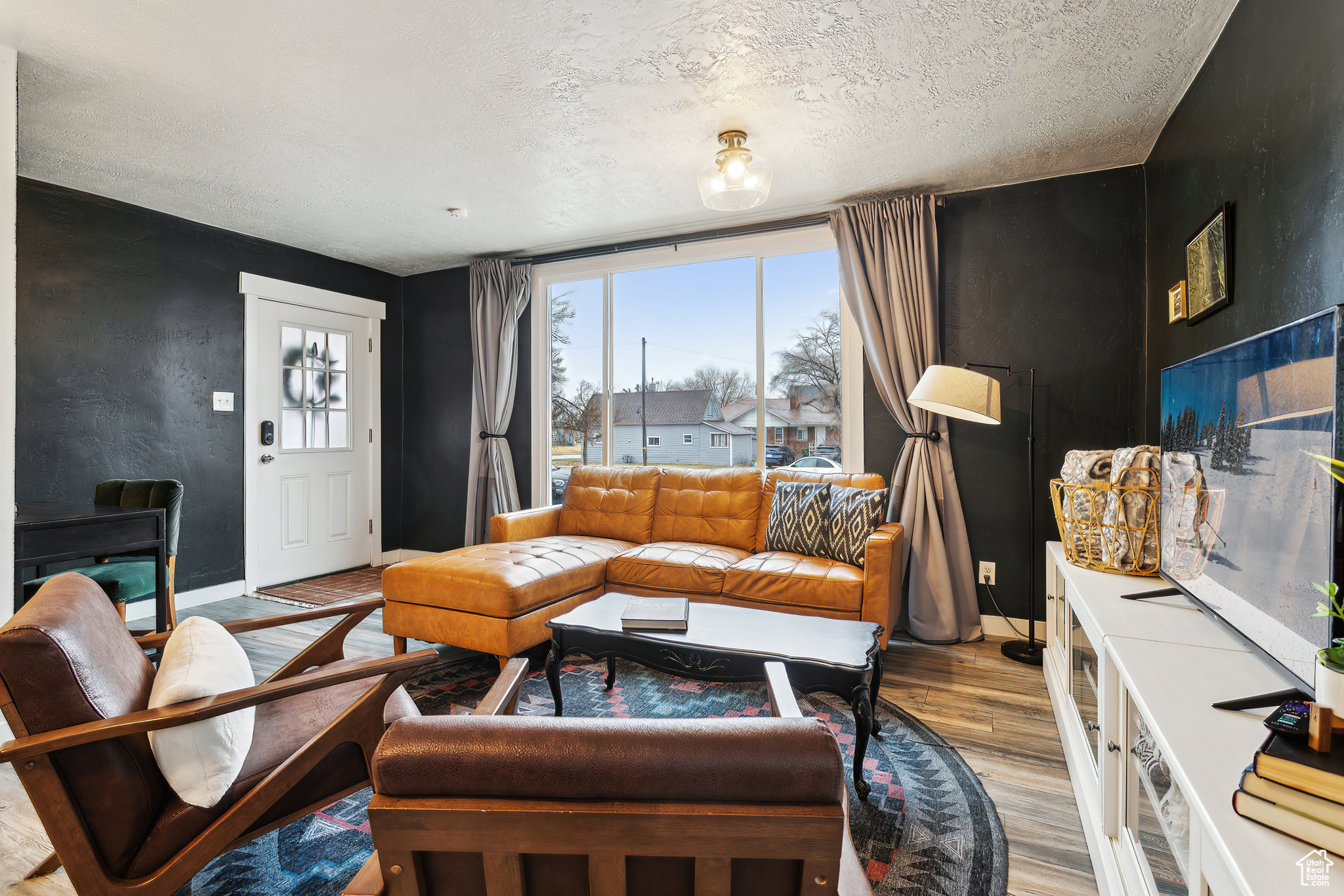 Living room with a textured ceiling and light wood-type flooring