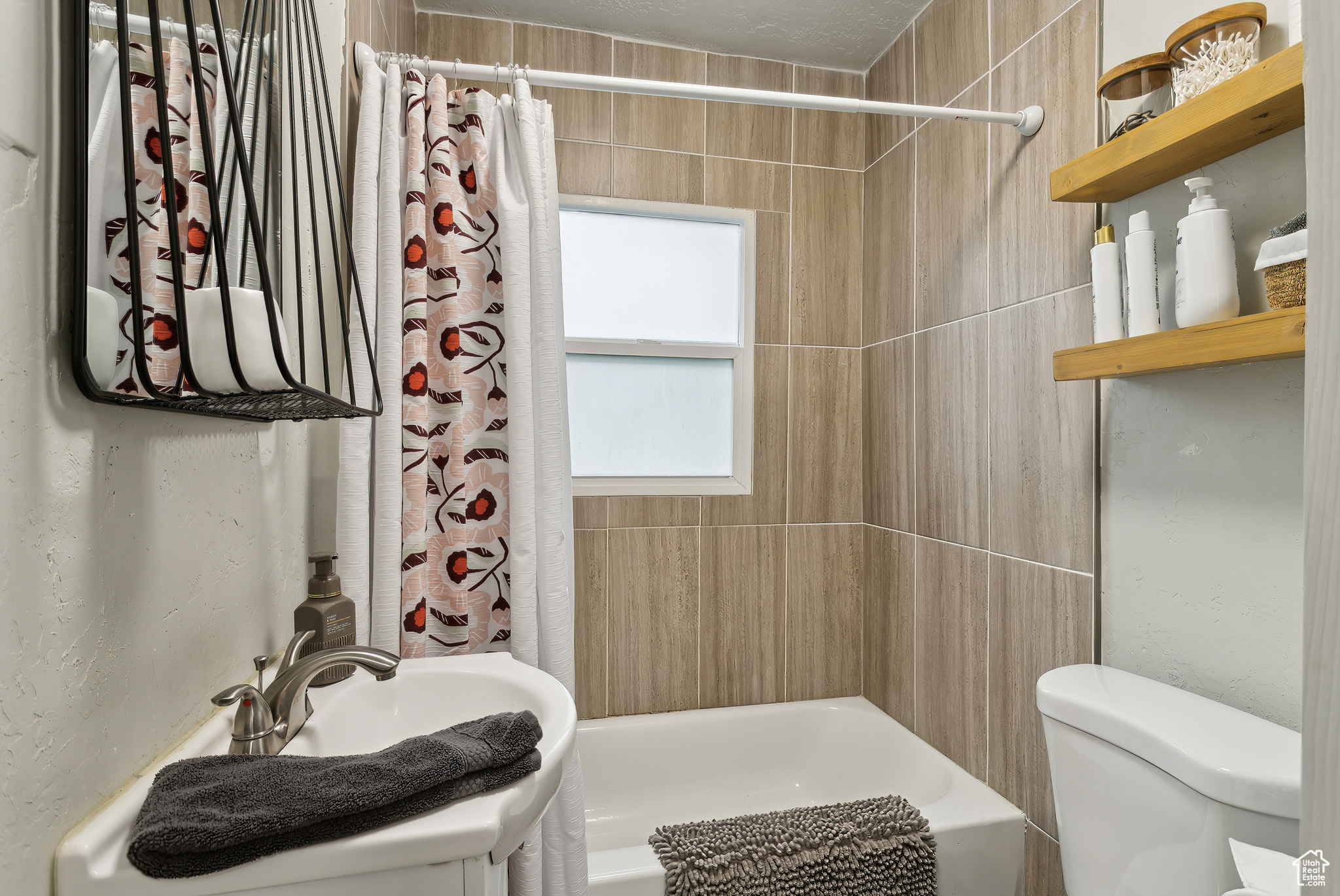 Full bathroom featuring sink, shower / bath combination with curtain, and toilet