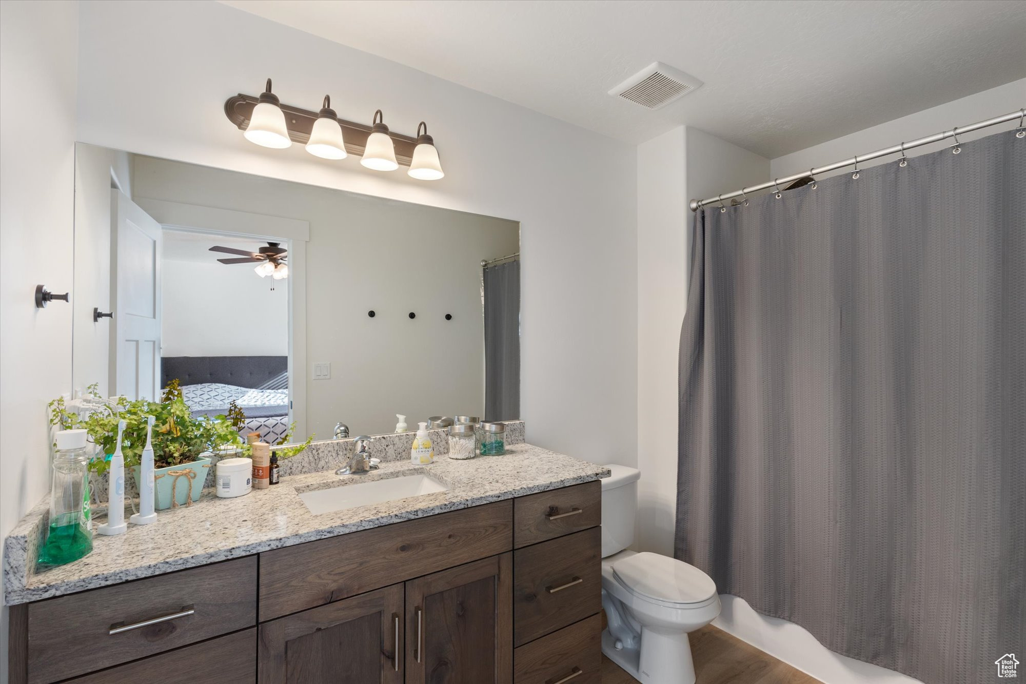 Bathroom with vanity, ceiling fan, and toilet