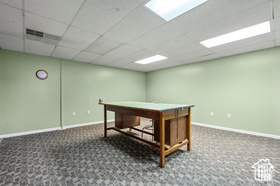 Recreation room featuring carpet floors and a paneled ceiling