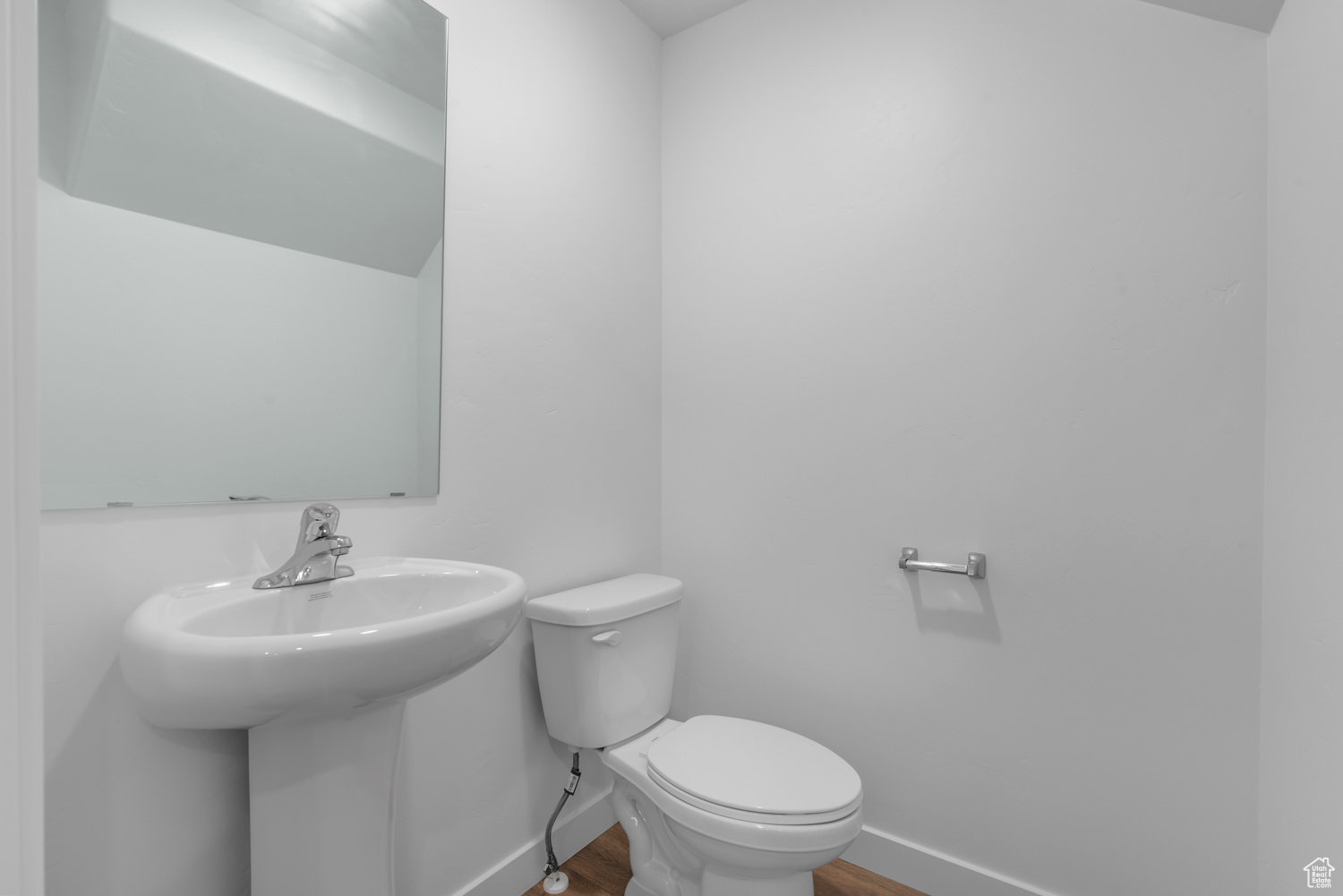 Bathroom featuring wood-type flooring, toilet, and sink