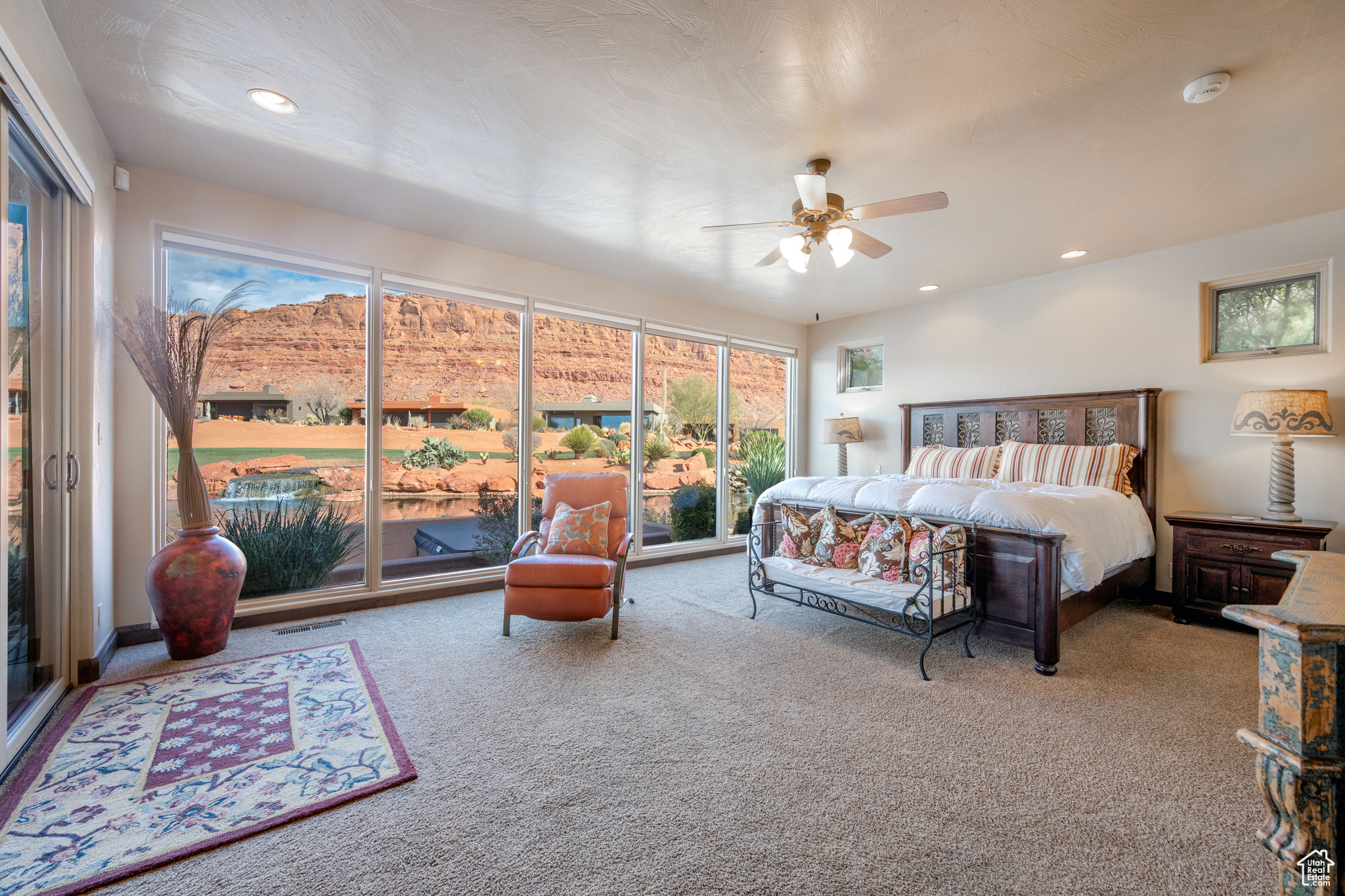 Bedroom with ceiling fan and light carpet