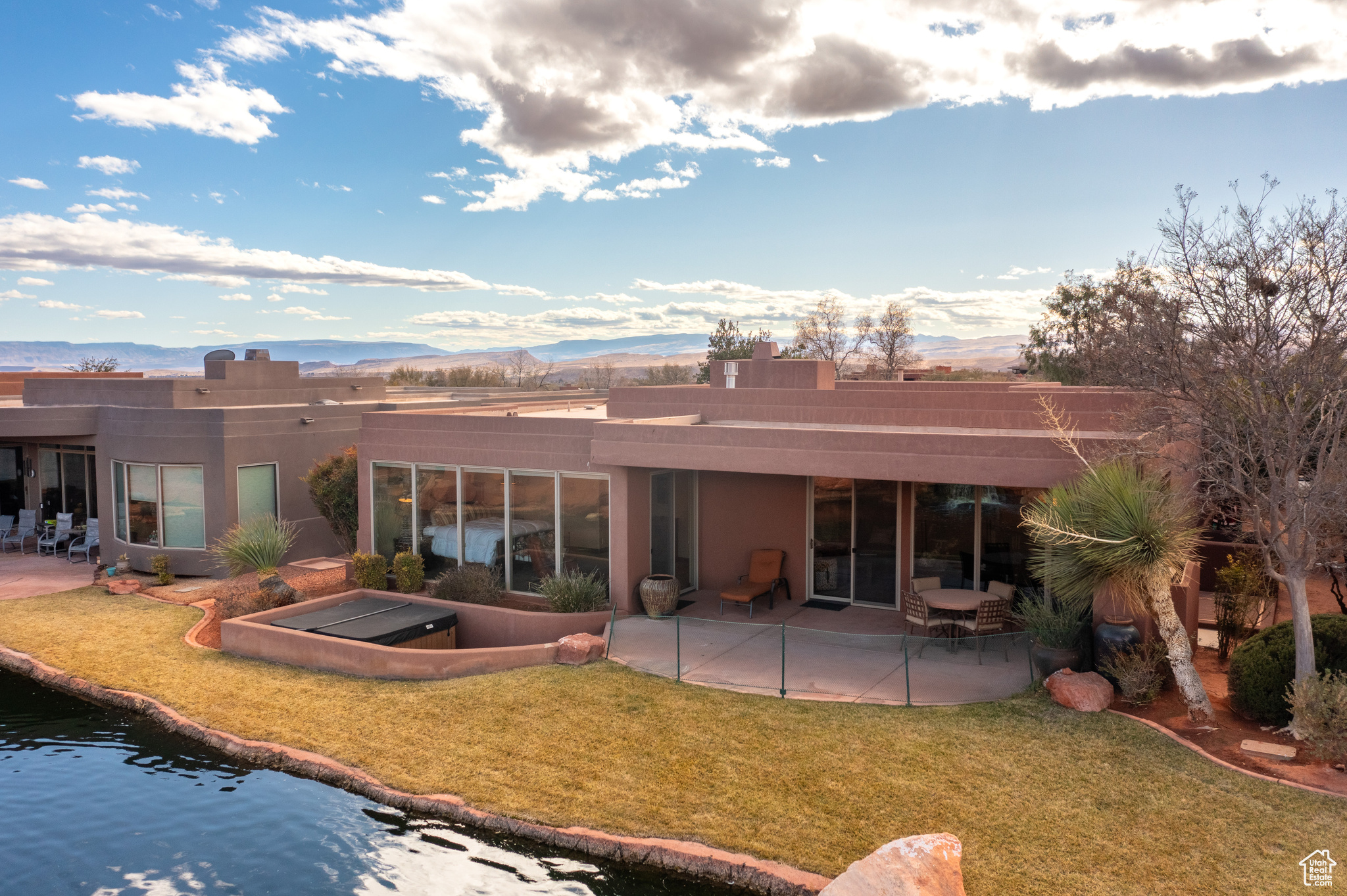 Rear view of house with a mountain view, a yard, and a patio area