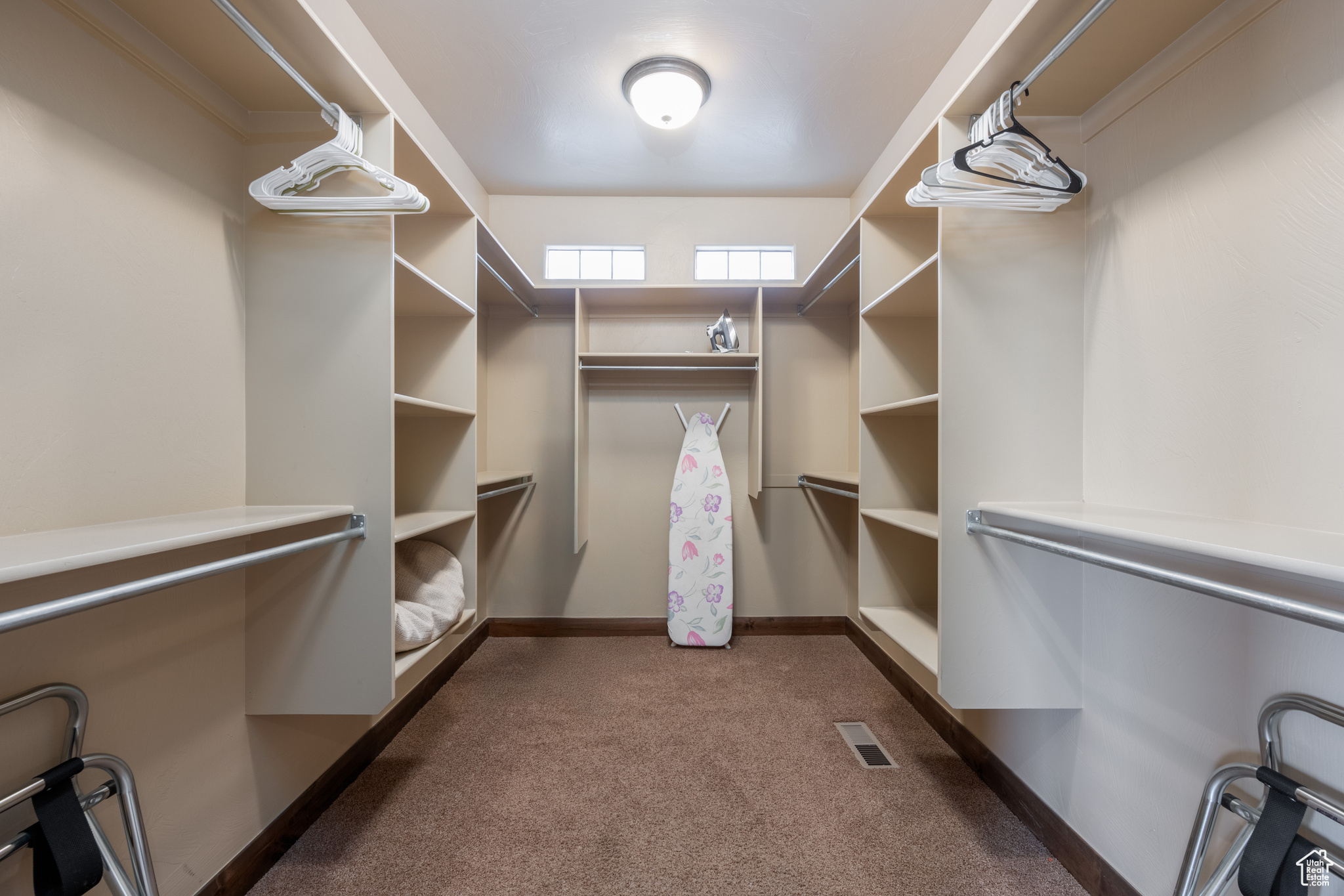 Spacious closet featuring dark colored carpet
