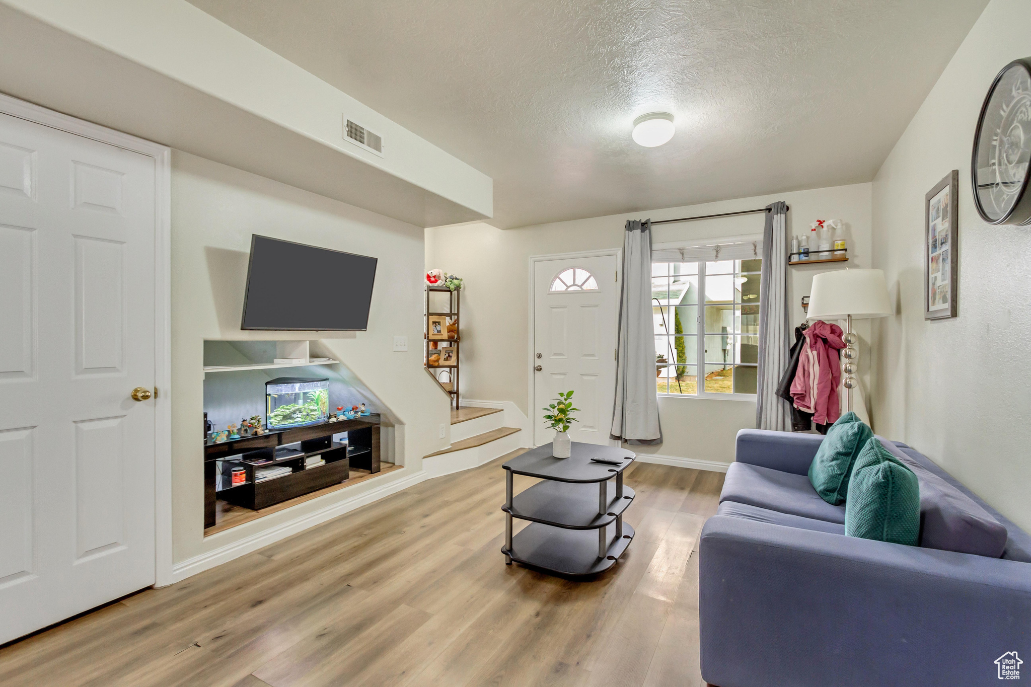 Living room with hardwood / wood-style floors and a textured ceiling