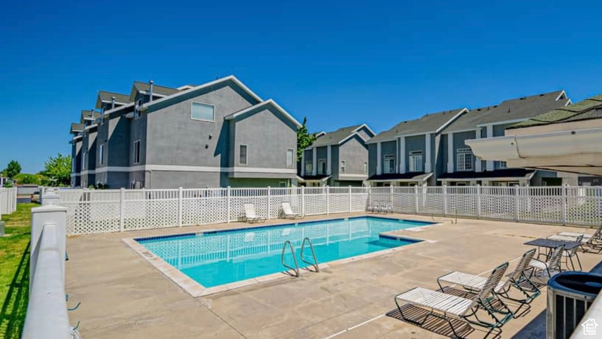 Pool with a residential view, fence, and a patio