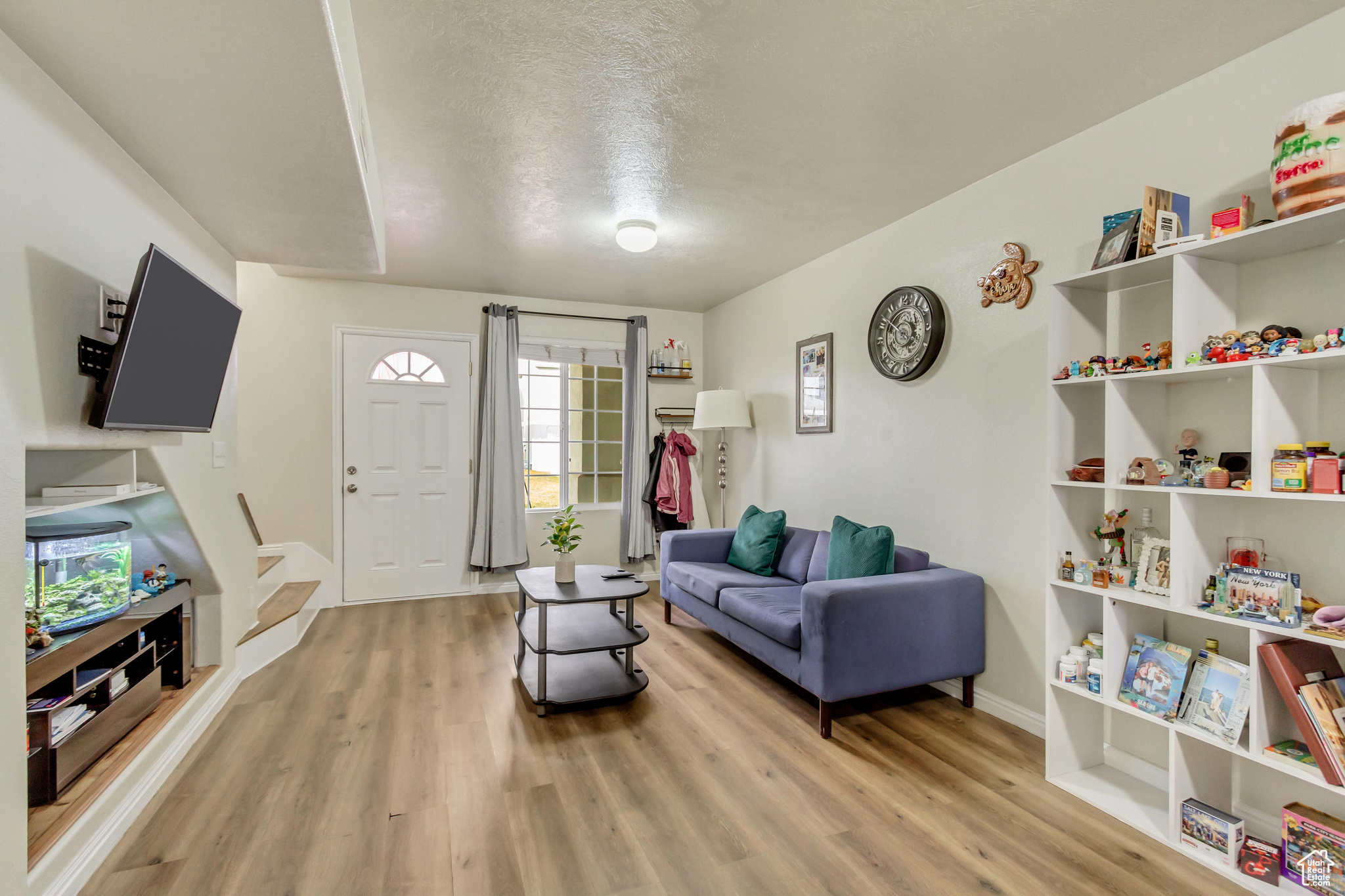Living room with a healthy amount of sunlight, a textured ceiling, and light wood-type flooring