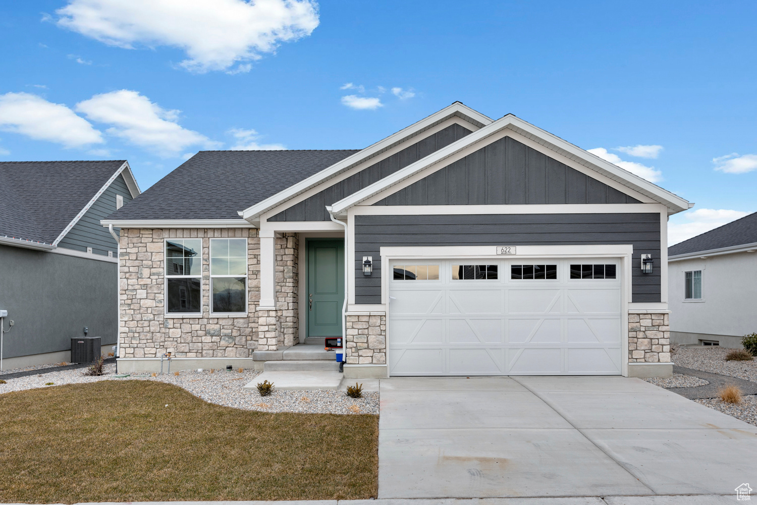 Craftsman-style home with cooling unit, a garage, and a front yard