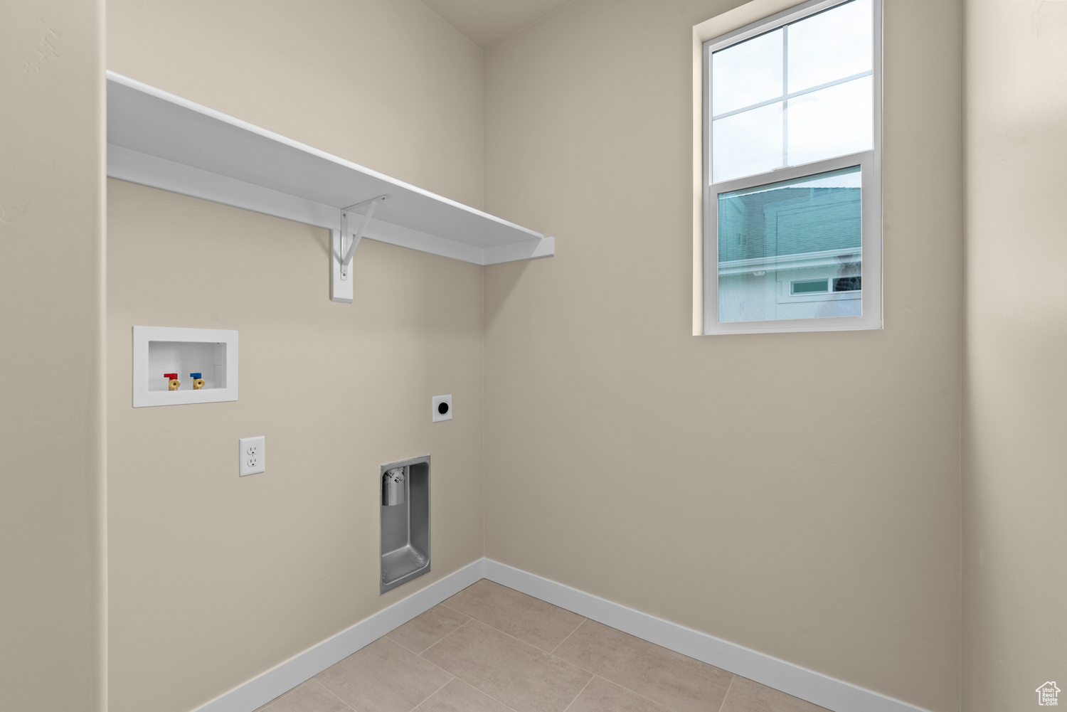 Clothes washing area featuring electric dryer hookup, washer hookup, and light tile patterned floors
