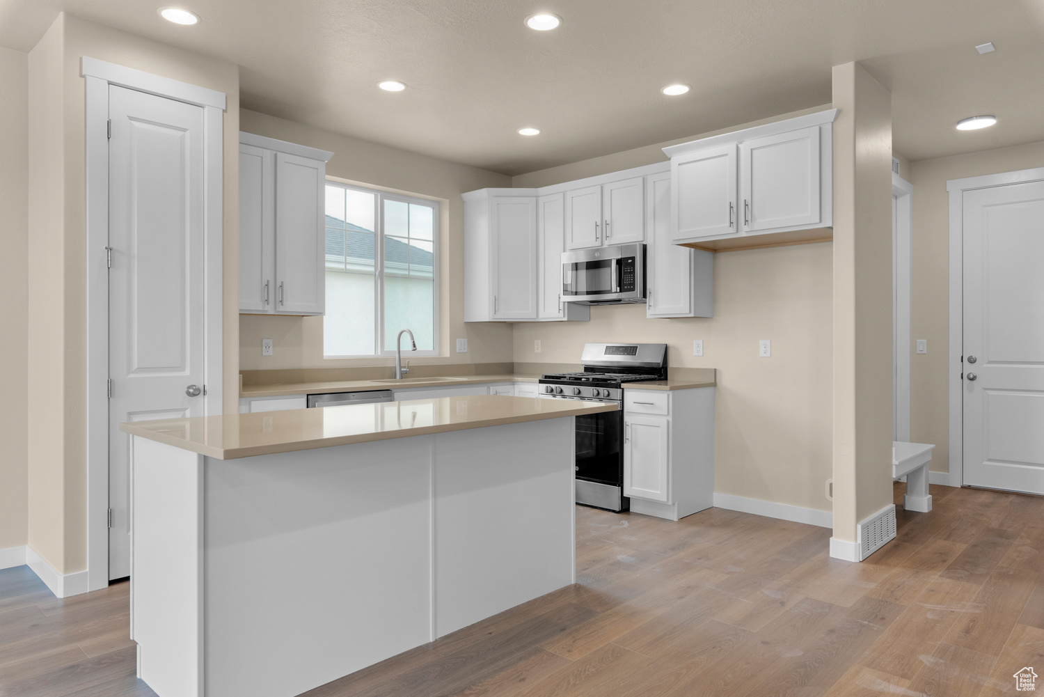 Kitchen with white cabinetry, a kitchen island, and appliances with stainless steel finishes