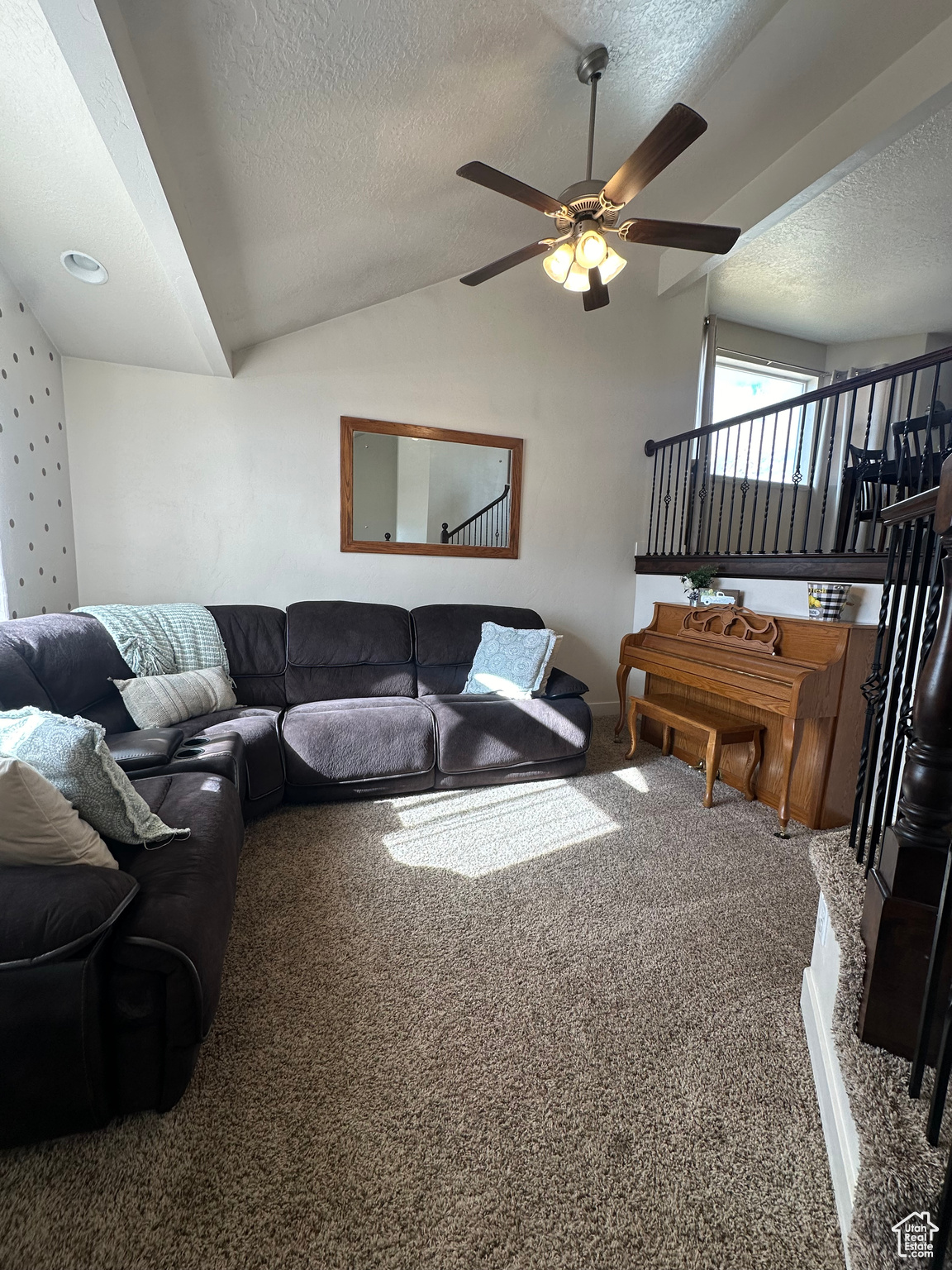 Main Living room featuring carpet floors, ceiling fan, vaulted ceiling, and a textured ceiling