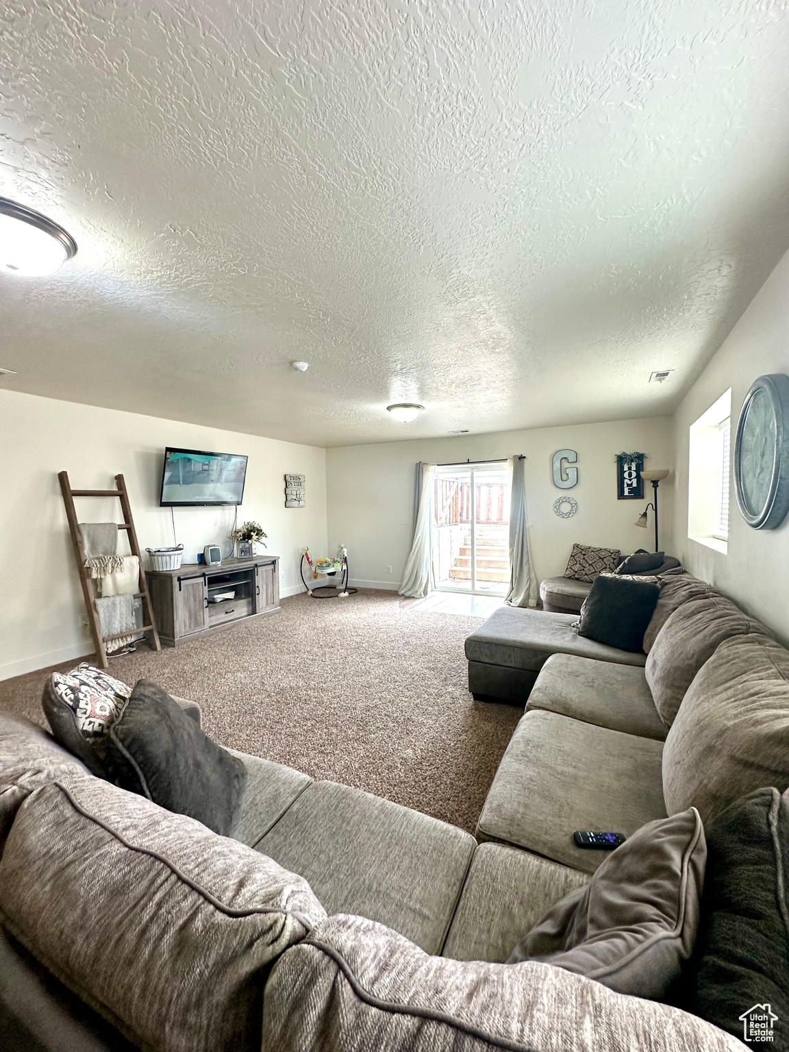 Carpeted living room featuring a textured ceiling