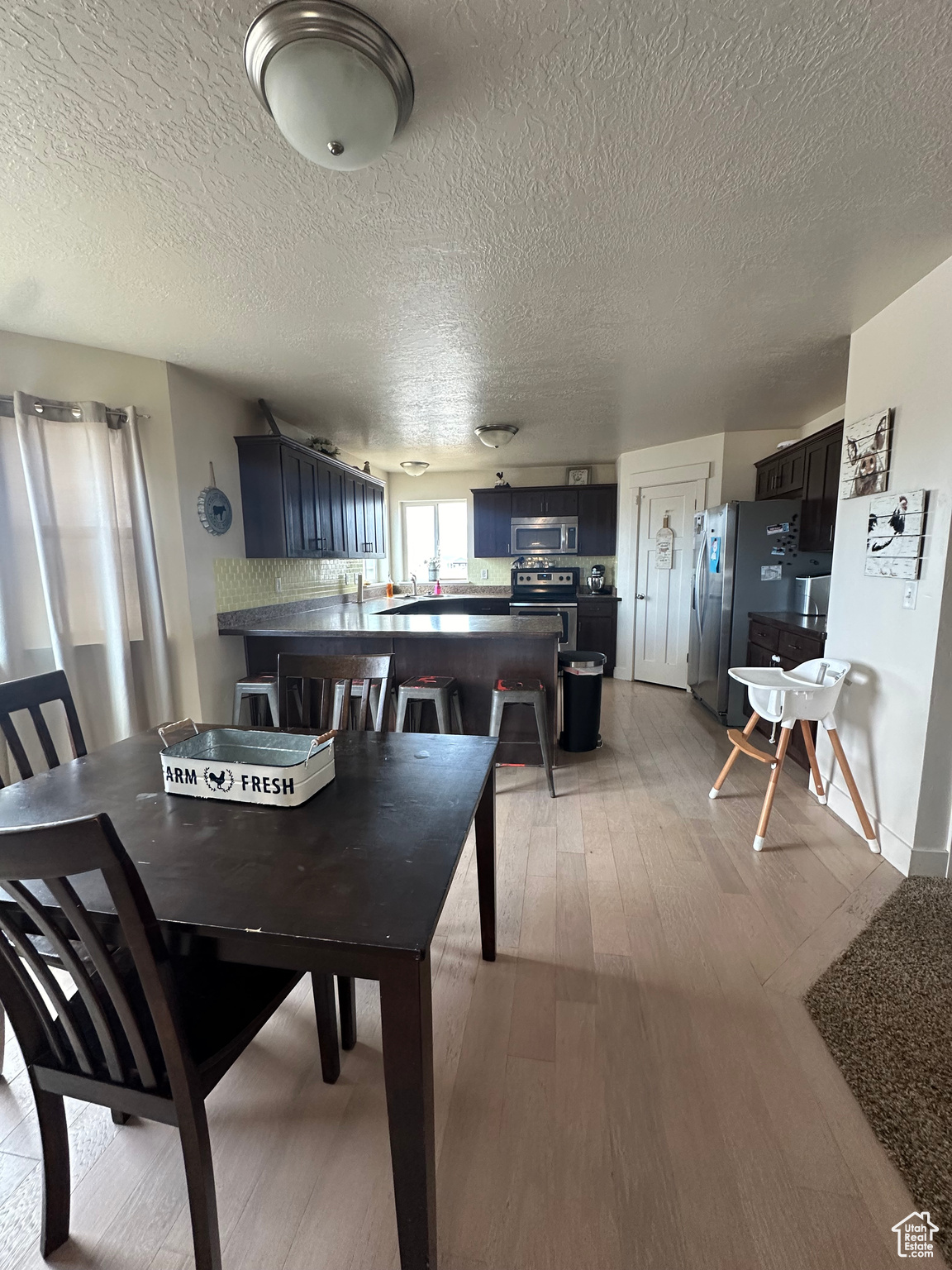 Dining space featuring a textured ceiling and light wood-type flooring
