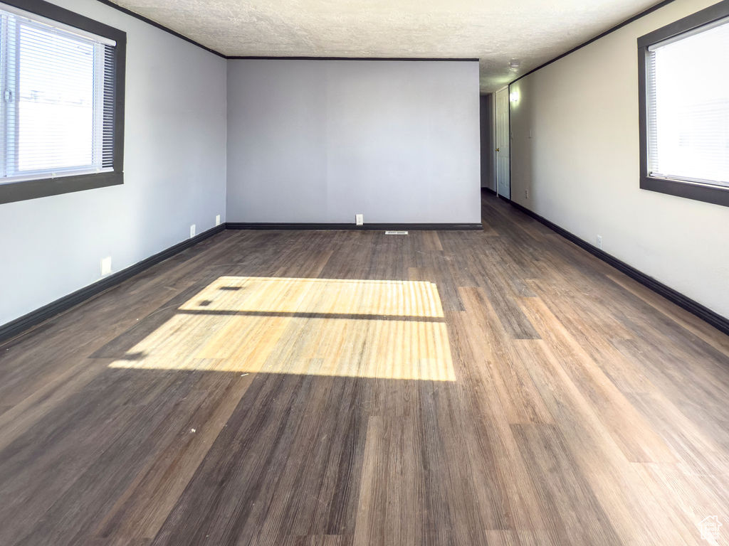 Empty room featuring hardwood / wood-style floors and a textured ceiling