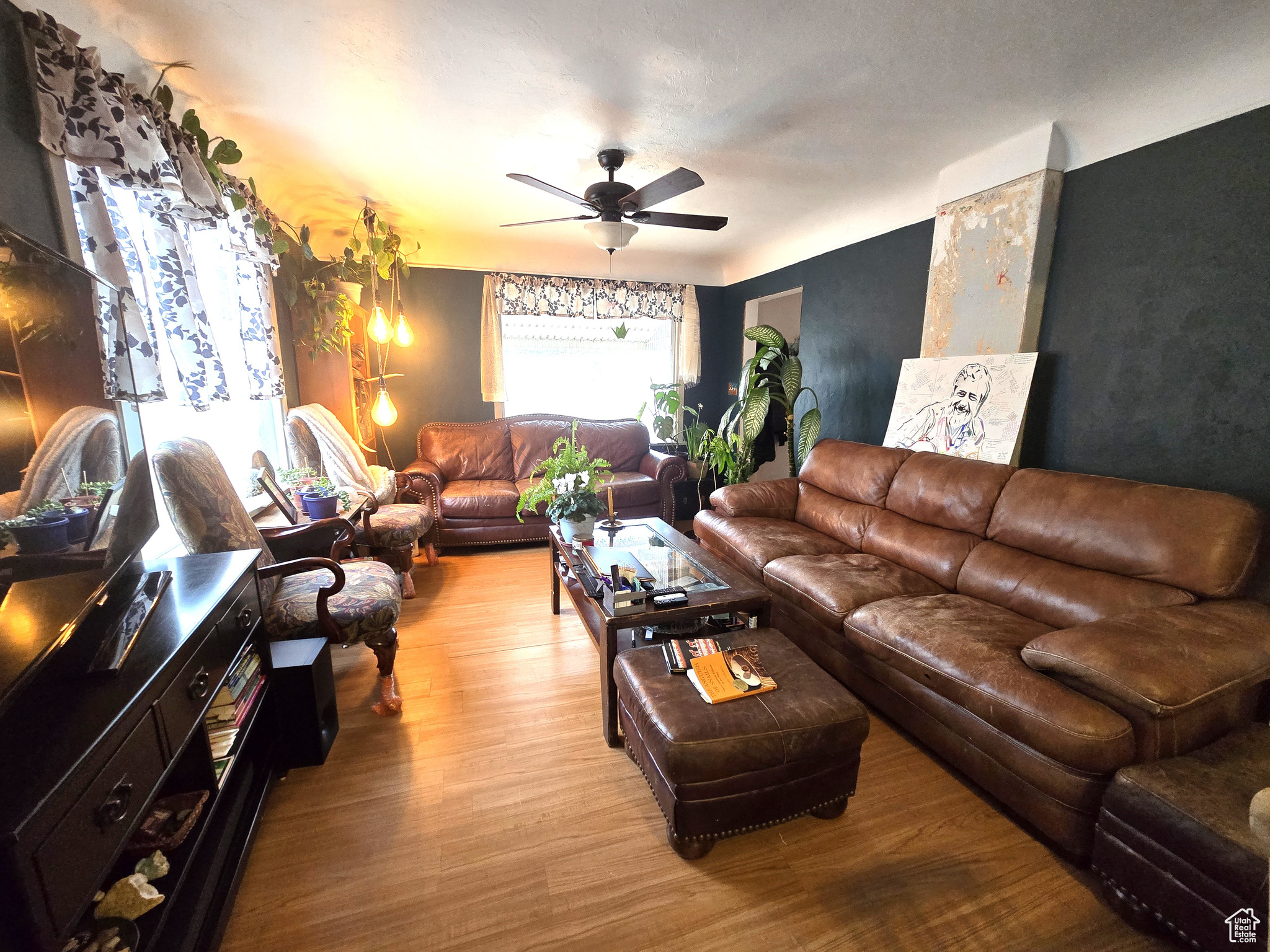 Living room with ceiling fan and light hardwood / wood-style floors