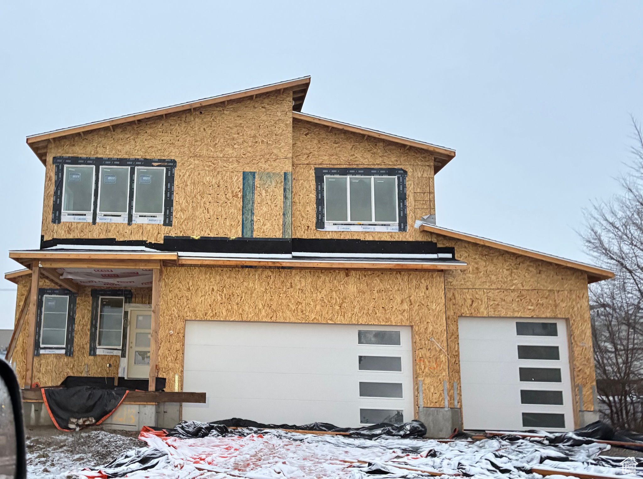 View of front of home with a garage and stucco siding