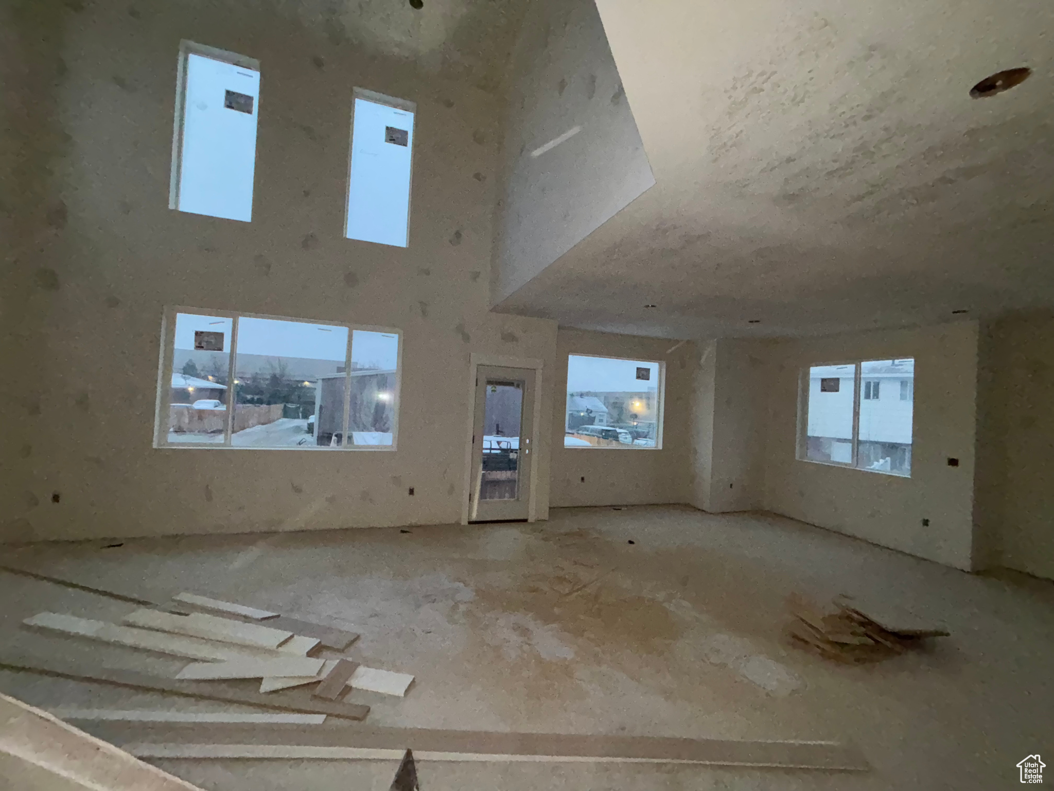 Unfurnished living room featuring a towering ceiling