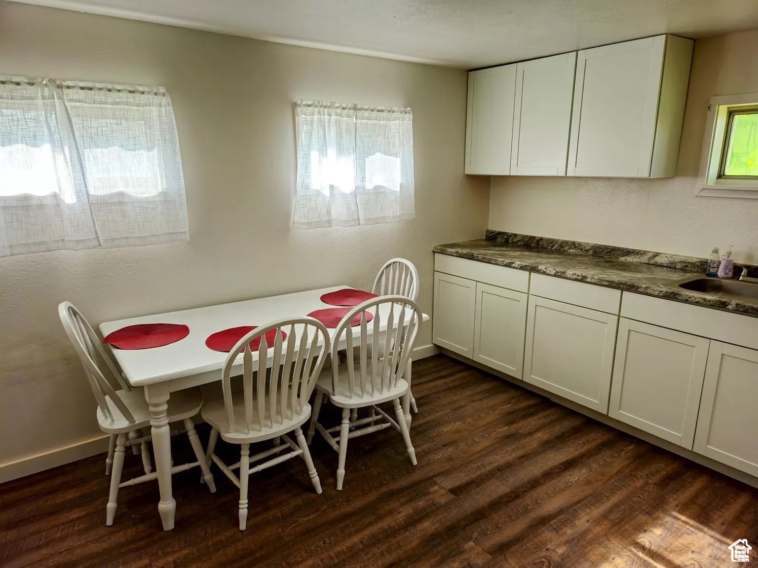 Dining area with dark hardwood / wood-style flooring and sink