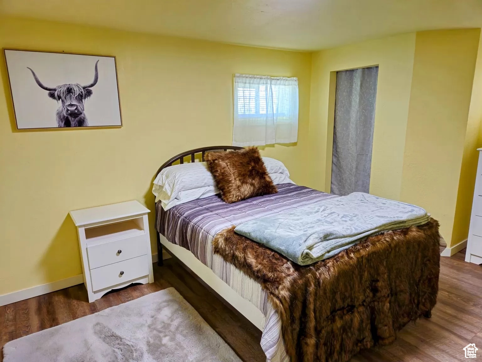 Bedroom with dark hardwood / wood-style flooring