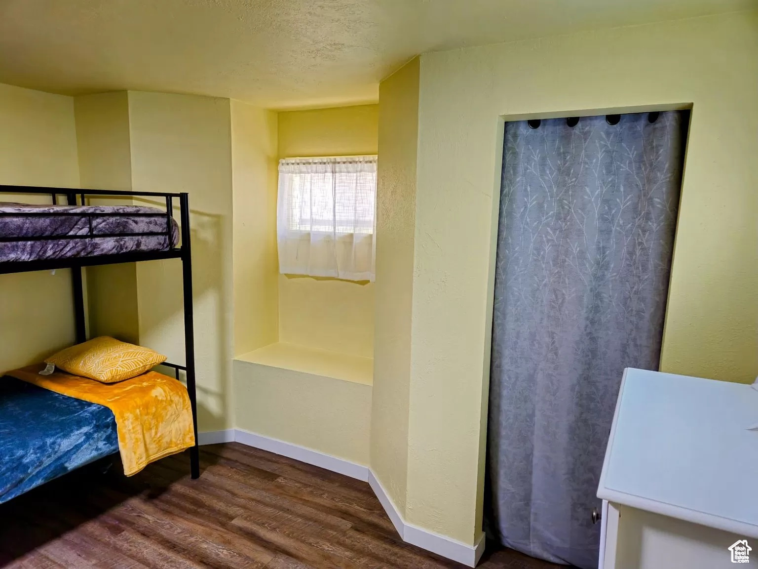 Bedroom with dark hardwood / wood-style flooring and a textured ceiling