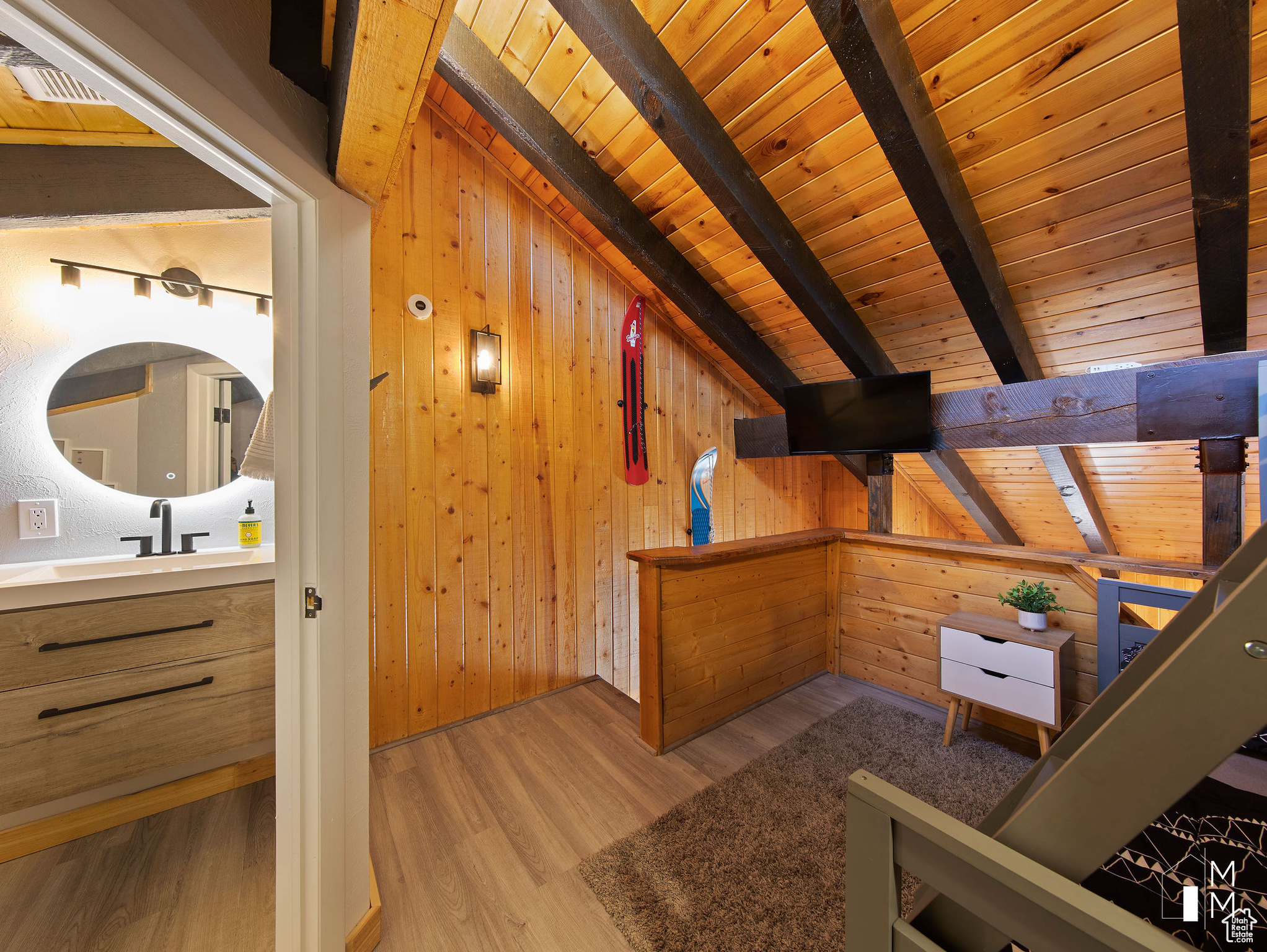 Additional living space with light hardwood / wood-style flooring, wooden ceiling, beamed ceiling, and wood walls