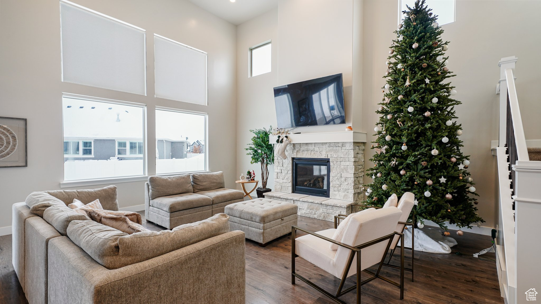 Living room featuring dark hardwood / wood-style floors, a fireplace, and a towering ceiling