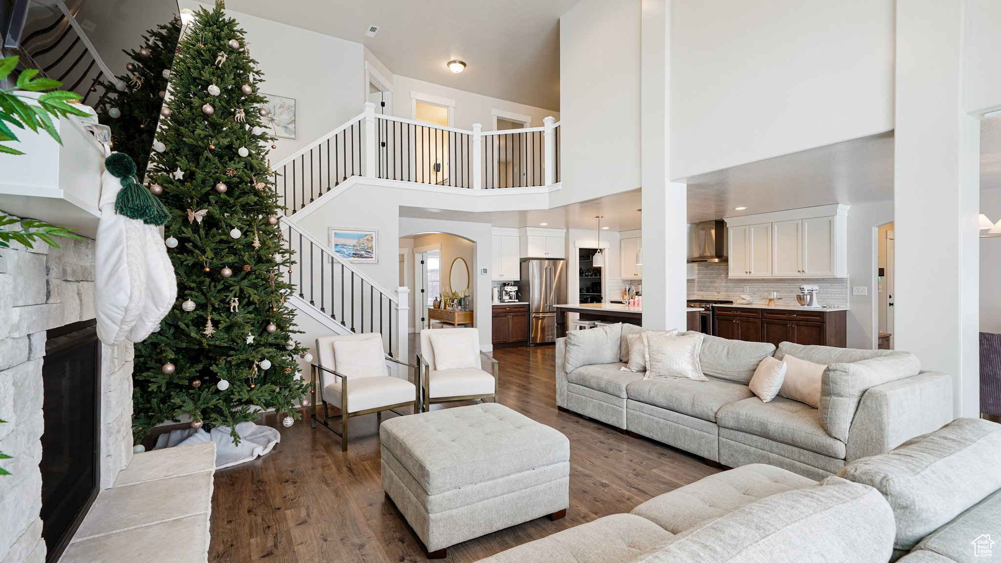 Living room with a stone fireplace and dark hardwood / wood-style floors