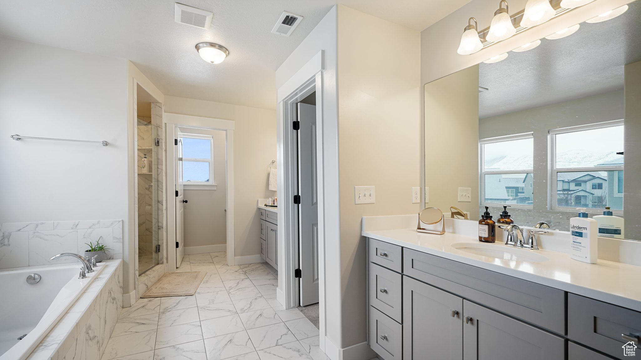Primary bathroom with vanity and shower with separate bathtub