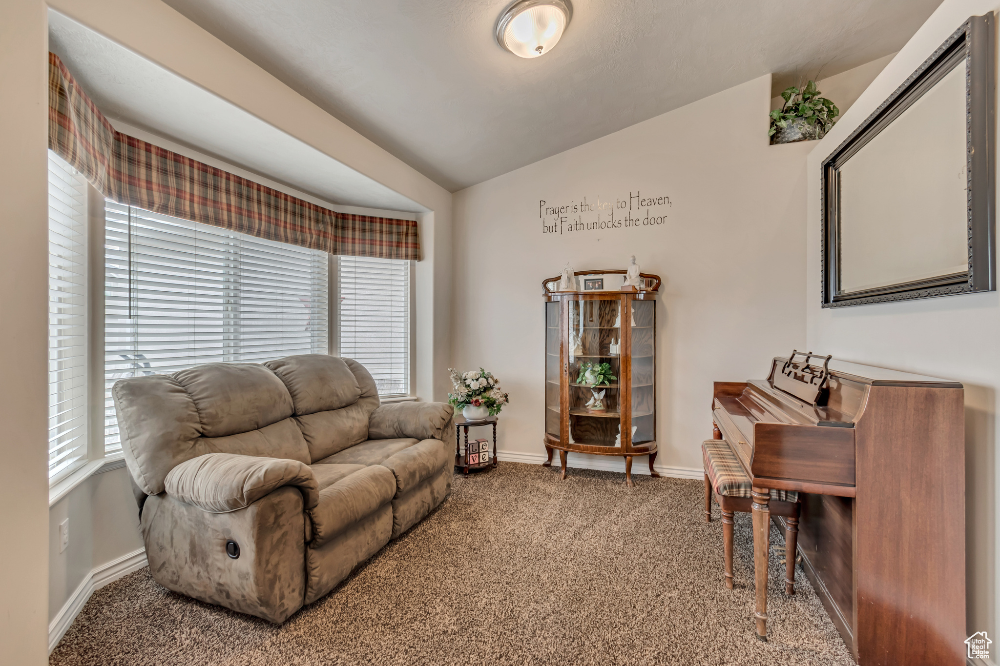 Living room featuring lofted ceiling, carpet flooring, and a wealth of natural light