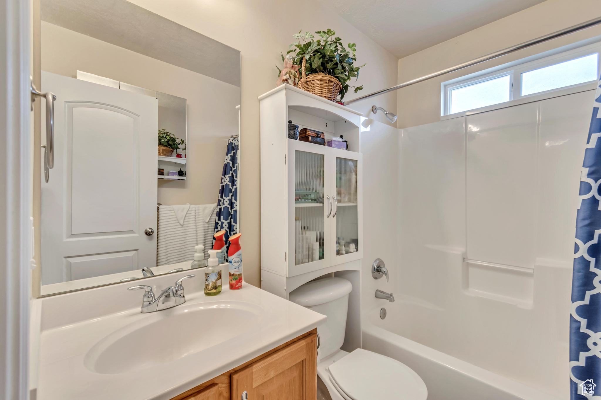 Full bathroom featuring vanity, shower / bathtub combination with curtain, and toilet