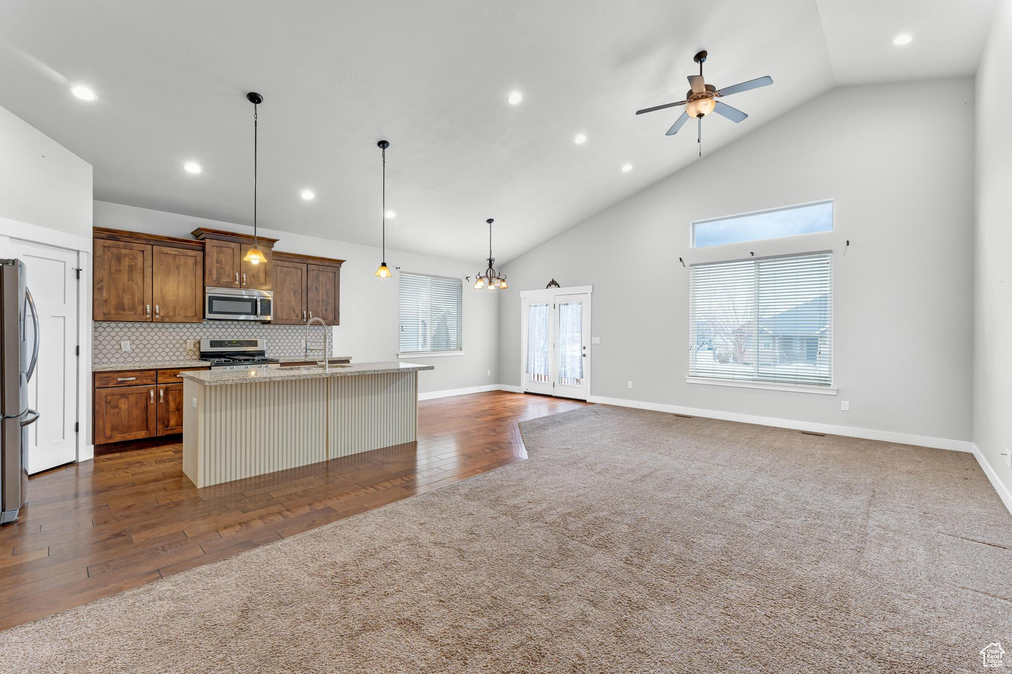 Open concept living with large windows + transom + glass doors