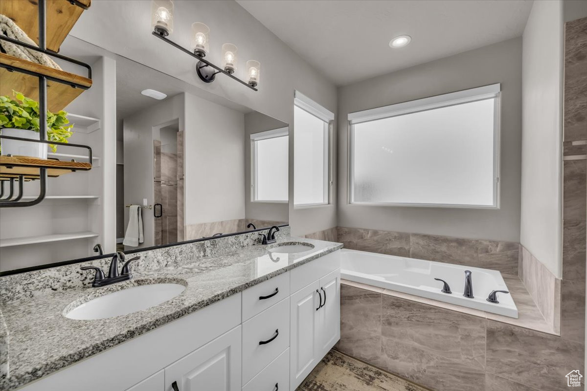 Bathroom featuring vanity and tiled tub