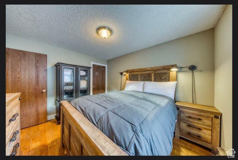 Bedroom featuring wood-type flooring and a textured ceiling