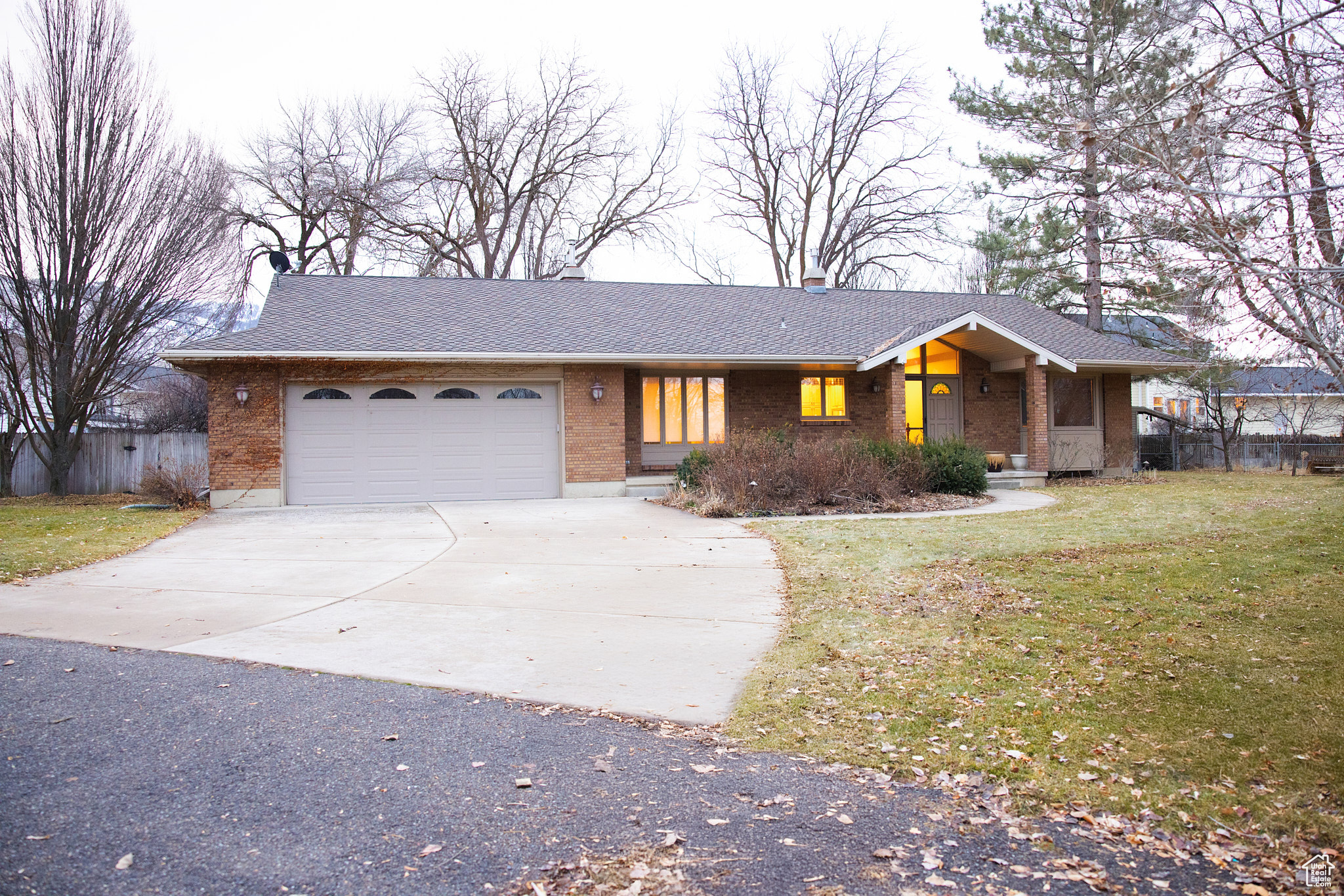 Ranch-style house featuring a garage and a front lawn