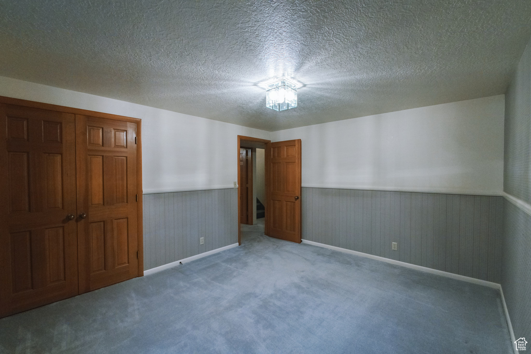 Carpeted spare room featuring a textured ceiling