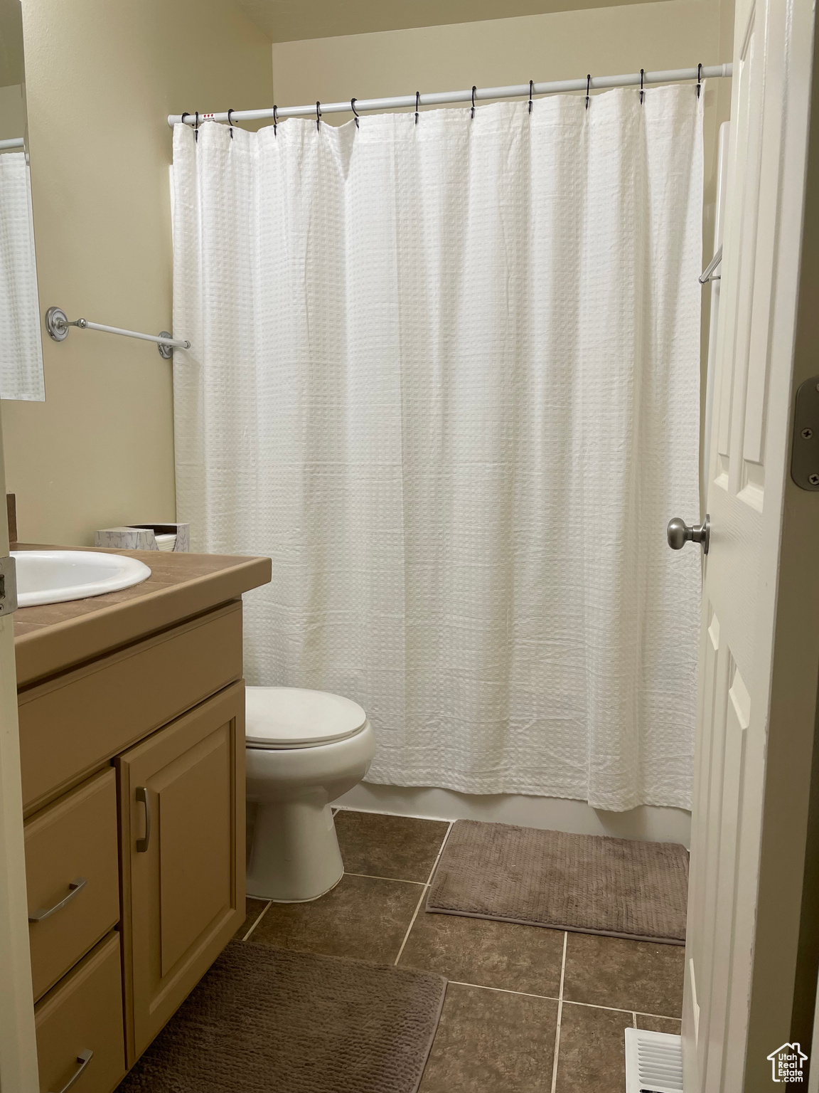 Full bathroom featuring shower / bathtub combination with curtain, tile patterned floors, toilet, and vanity