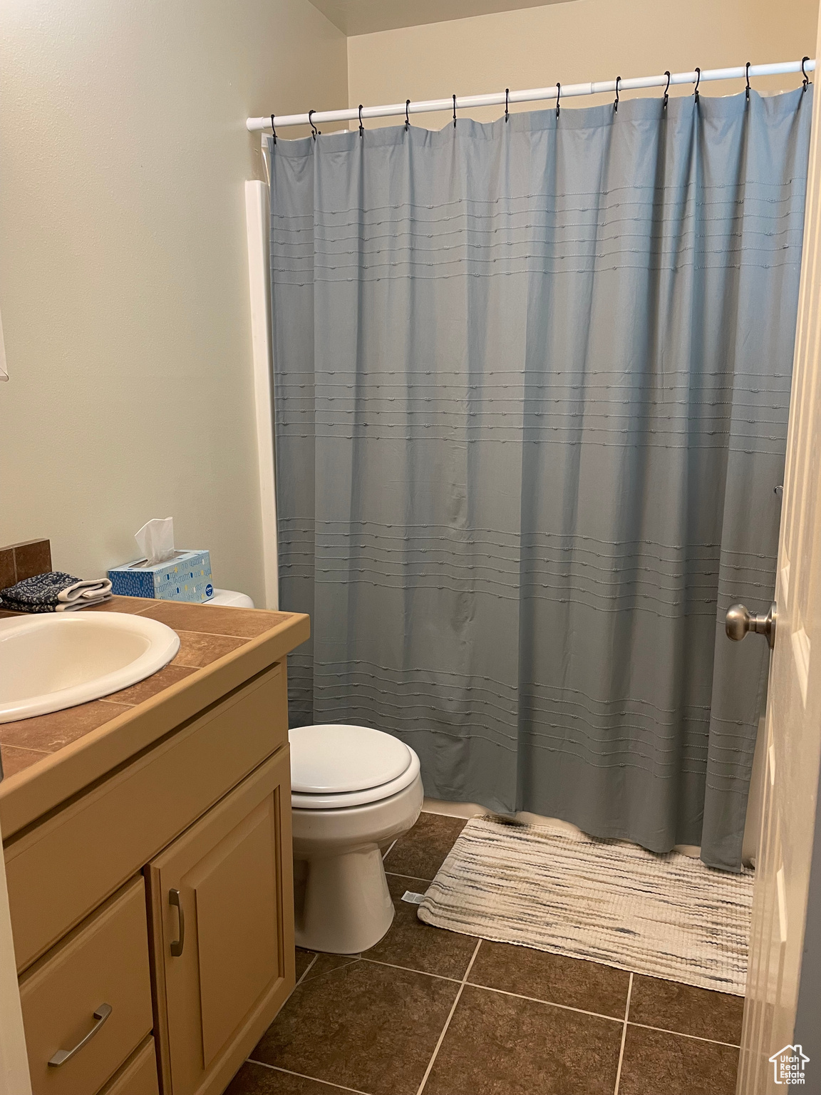 Bathroom featuring tile patterned flooring, vanity, a shower with curtain, and toilet
