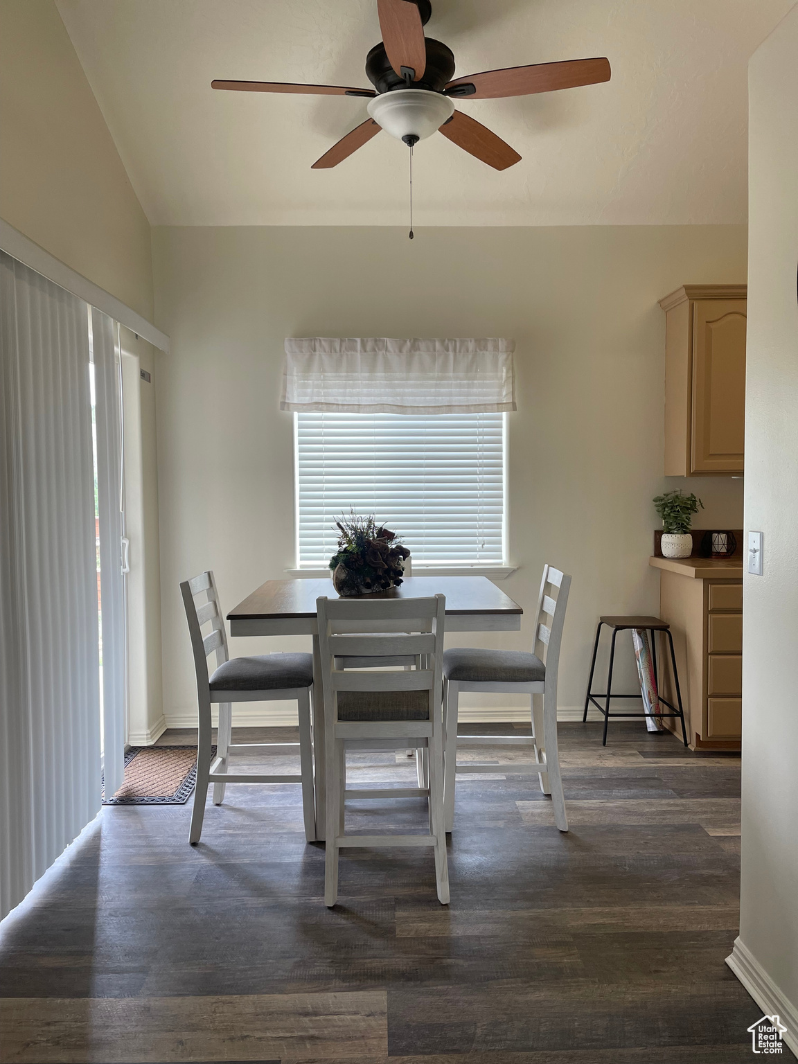Dining area with vaulted ceiling, dark hardwood / wood-style floors, and ceiling fan