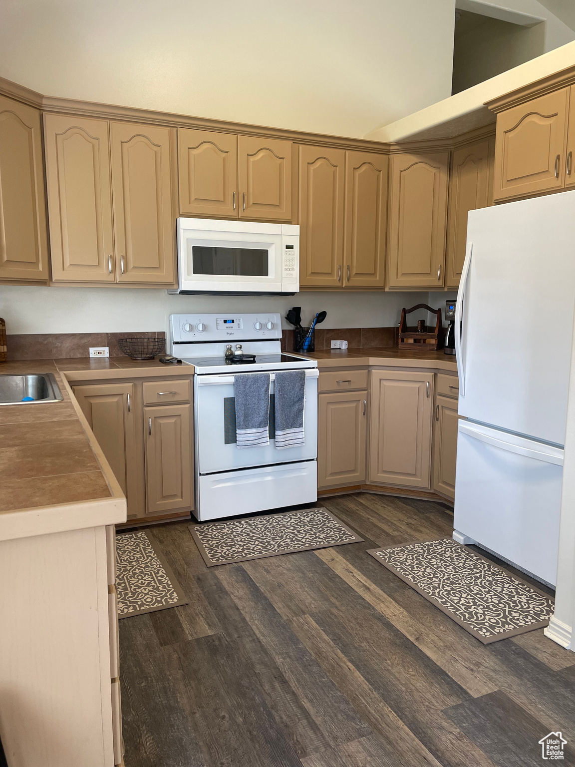 Kitchen with dark hardwood / wood-style flooring, sink, and white appliances