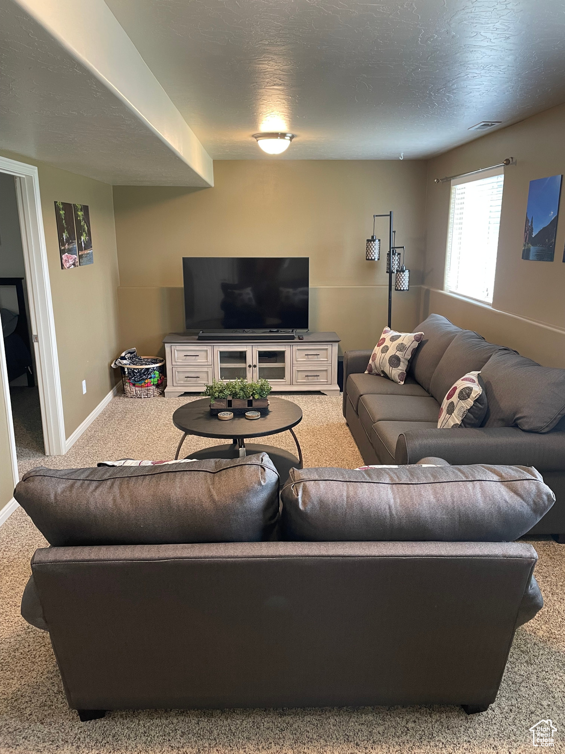 Carpeted living room featuring a textured ceiling