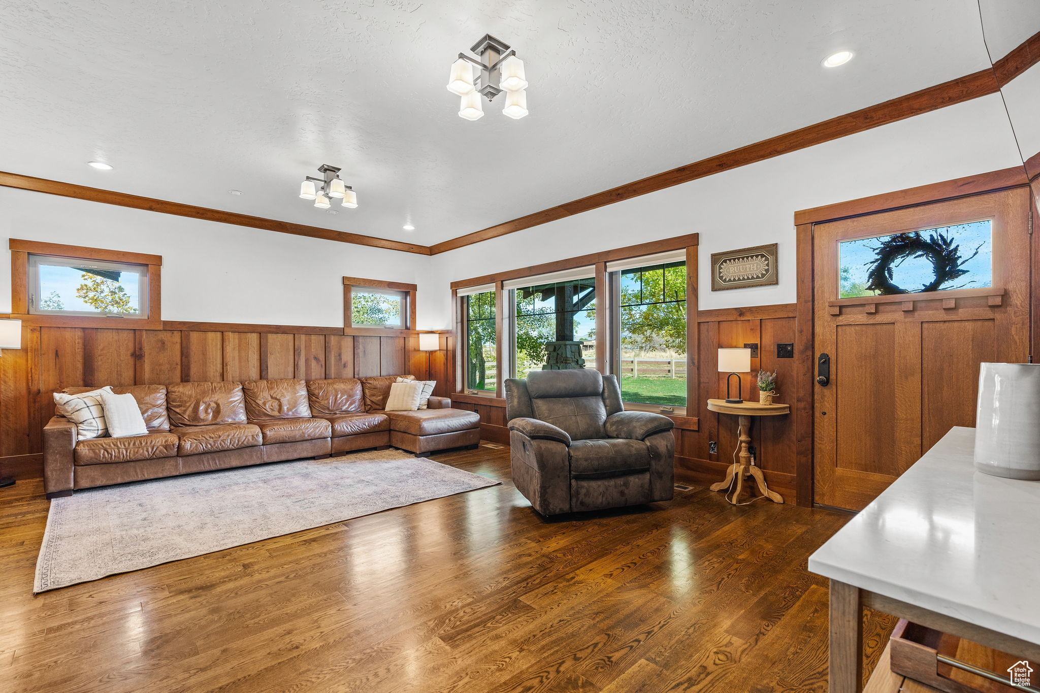 Living room featuring ornamental molding, dark hardwood / wood-style flooring, and a chandelier