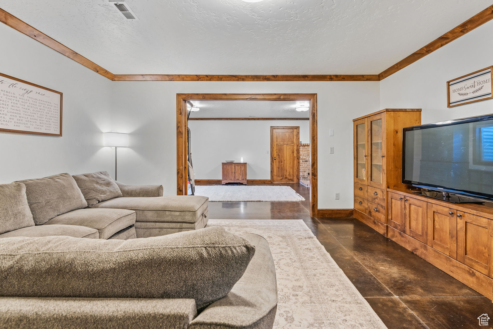 Living room featuring ornamental molding and a textured ceiling