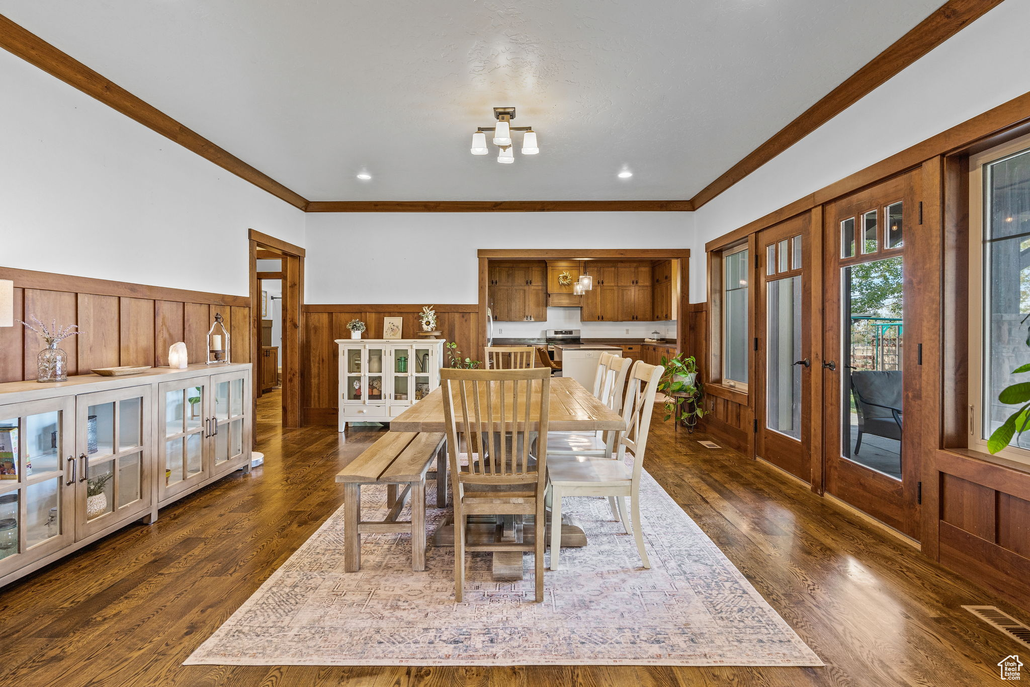 Dining area with french doors, ornamental molding, and dark wood-type flooring