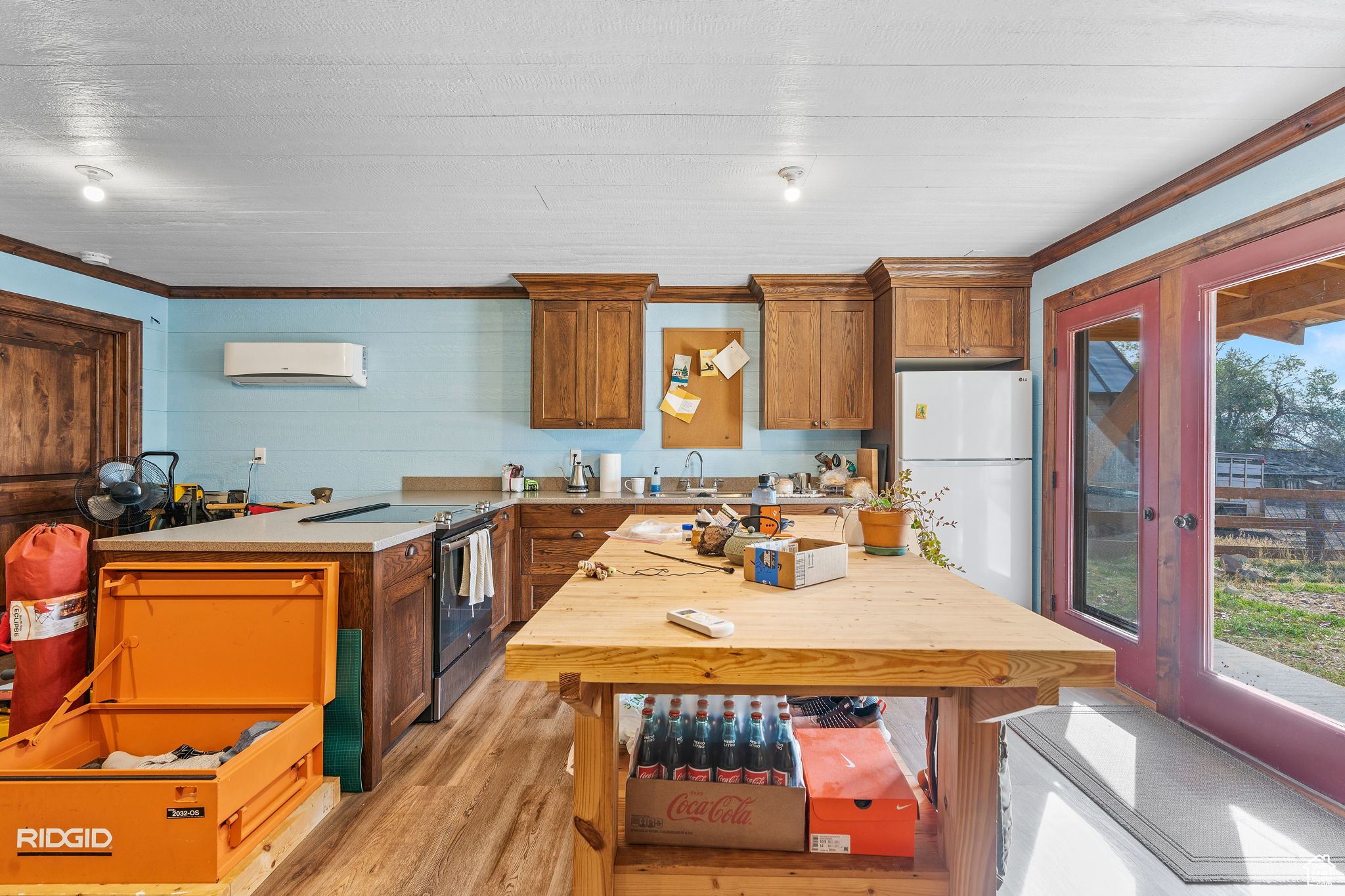 Kitchen with white refrigerator, light hardwood / wood-style floors, stainless steel range with electric cooktop, and a wealth of natural light