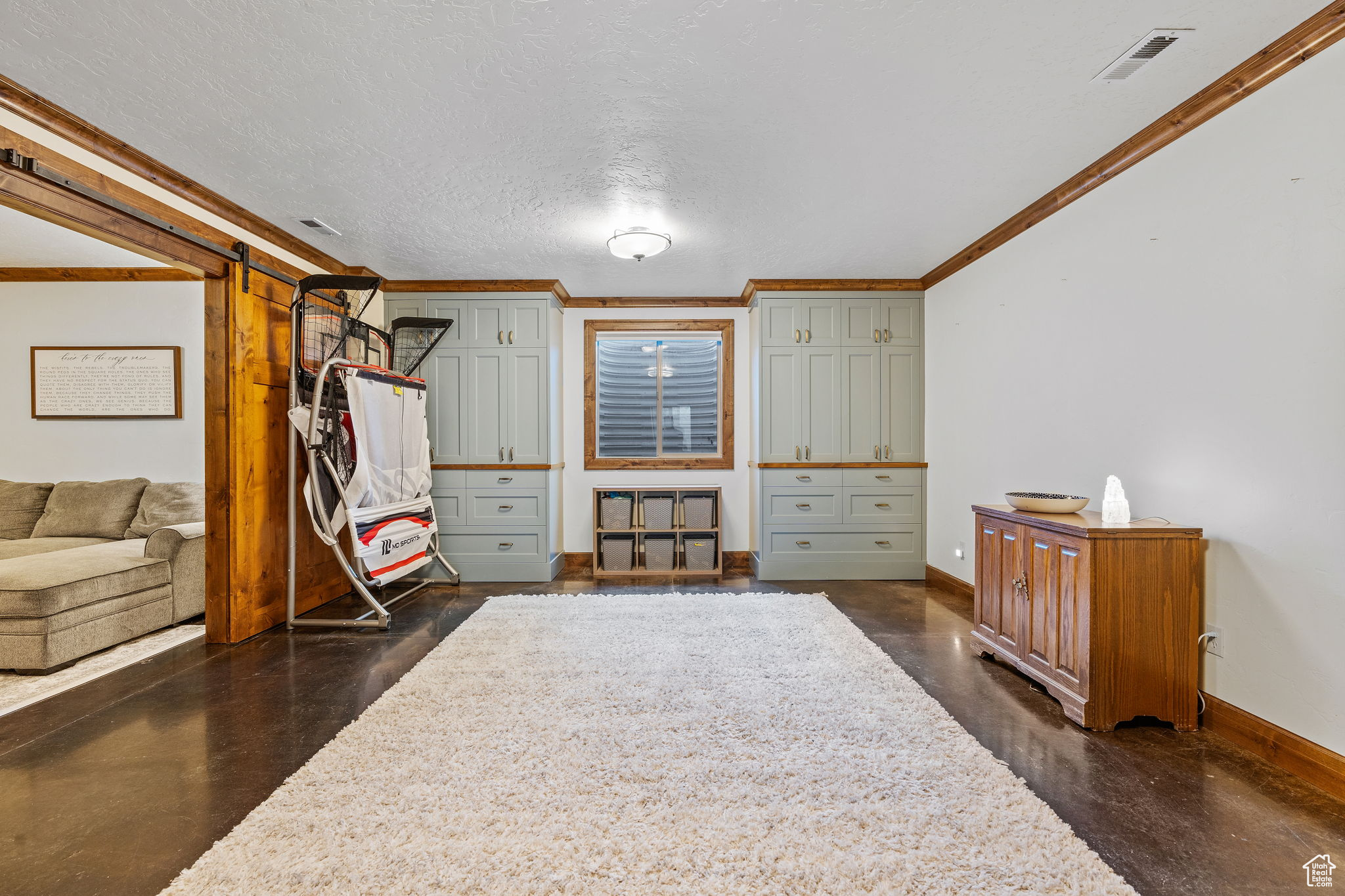 Interior space with crown molding and a textured ceiling