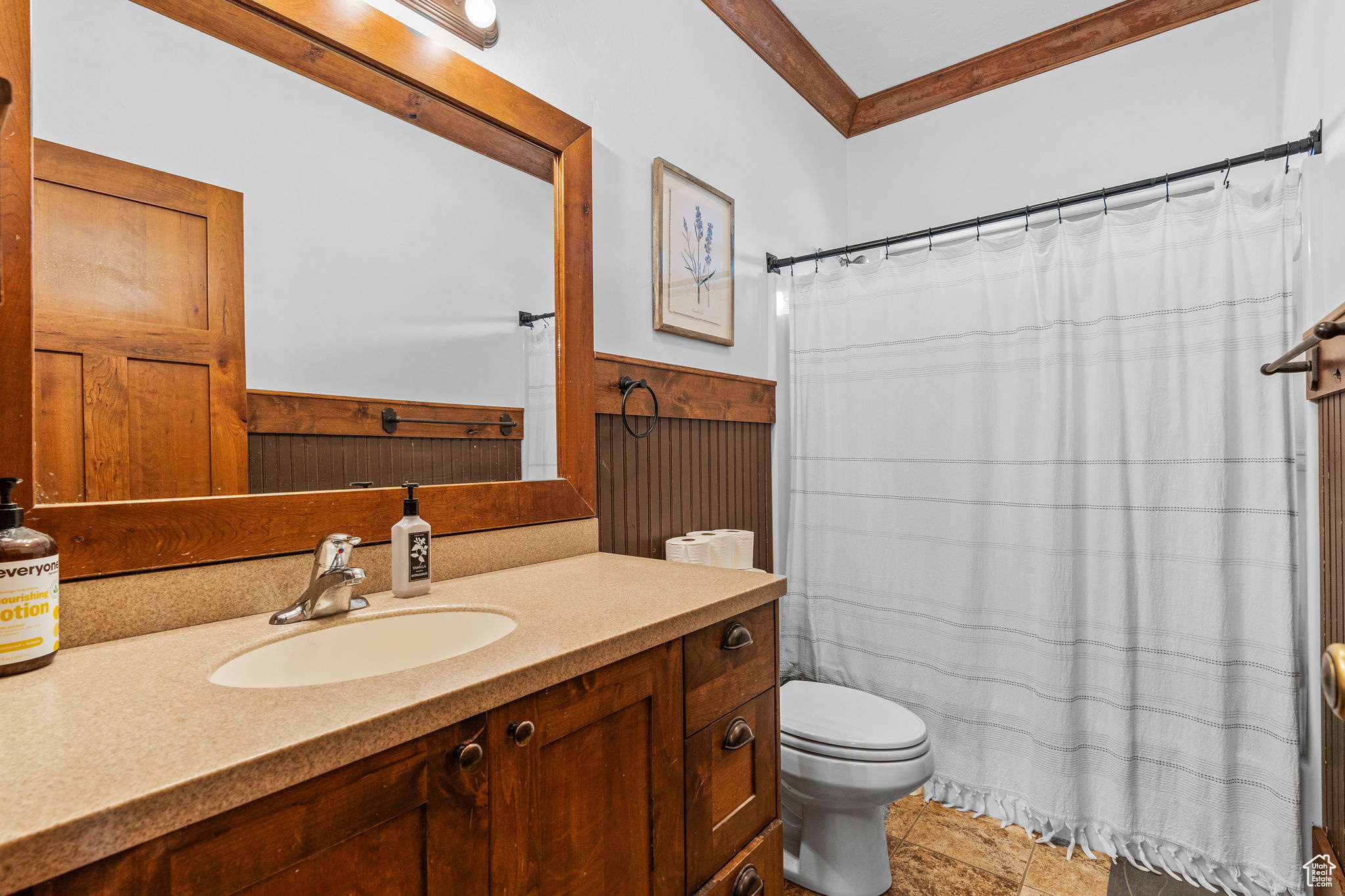 Bathroom featuring vanity, crown molding, and toilet