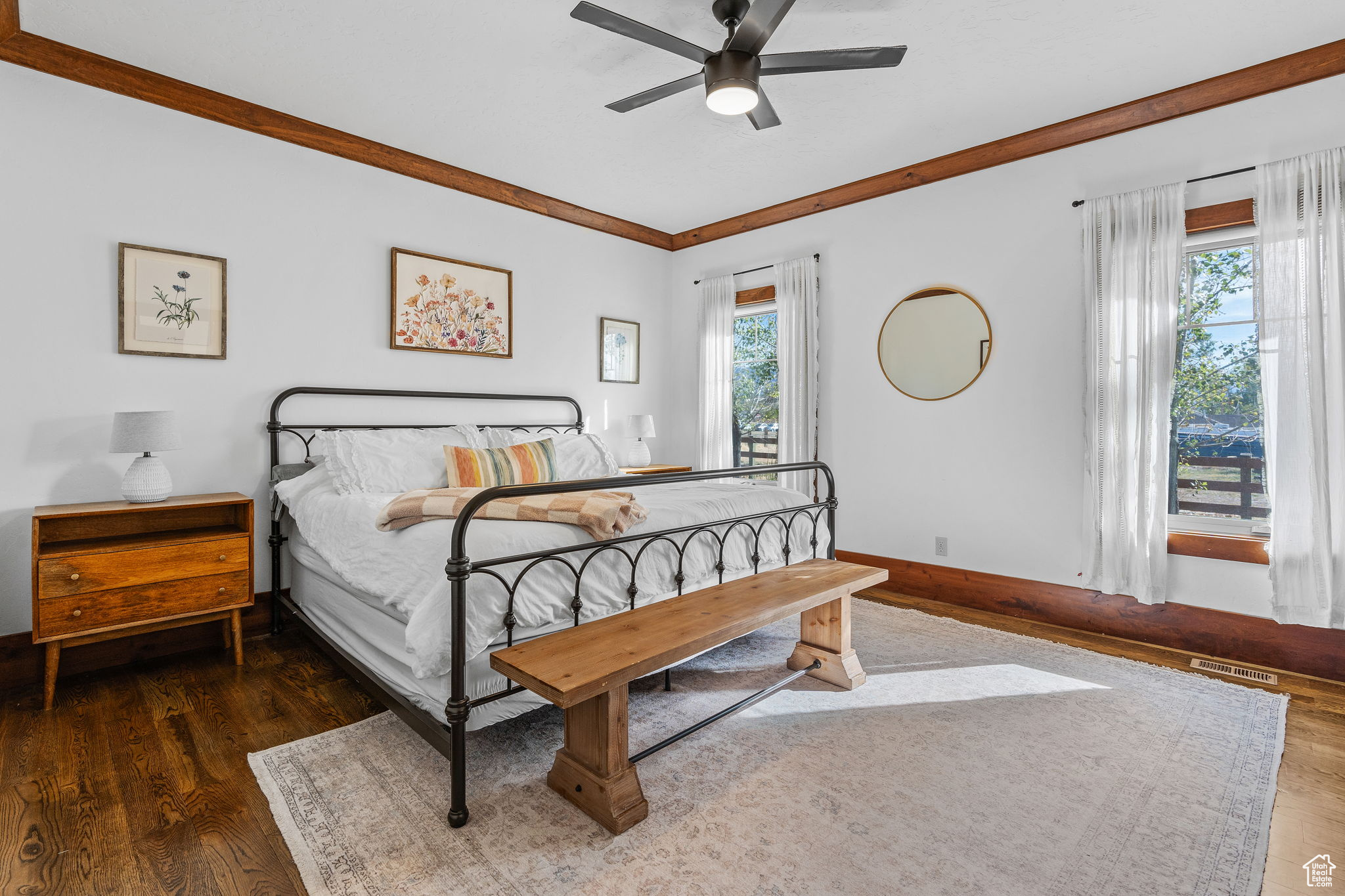 Bedroom with dark hardwood / wood-style flooring, crown molding, and ceiling fan