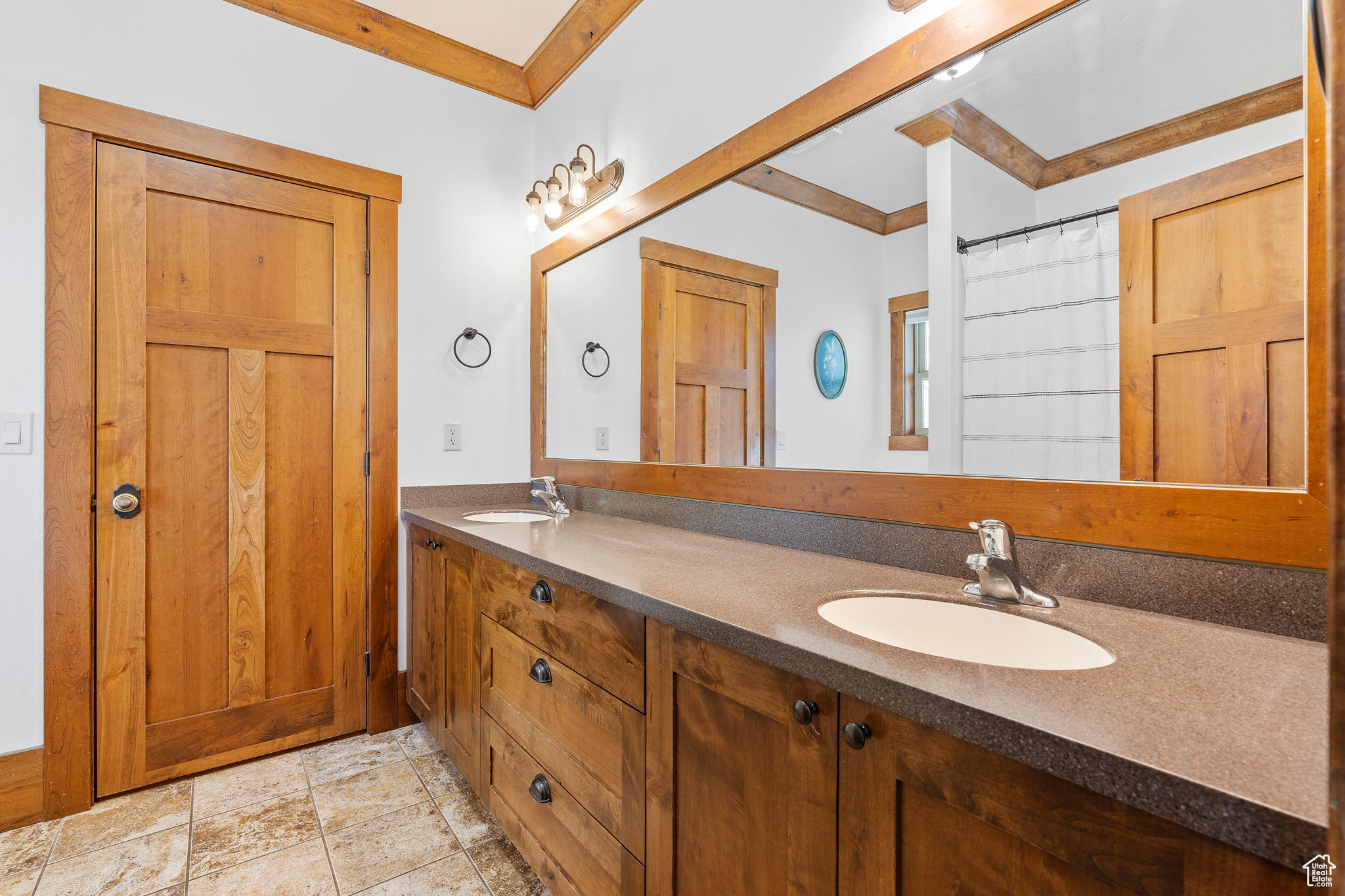 Bathroom with ornamental molding, vanity, and a shower with shower curtain