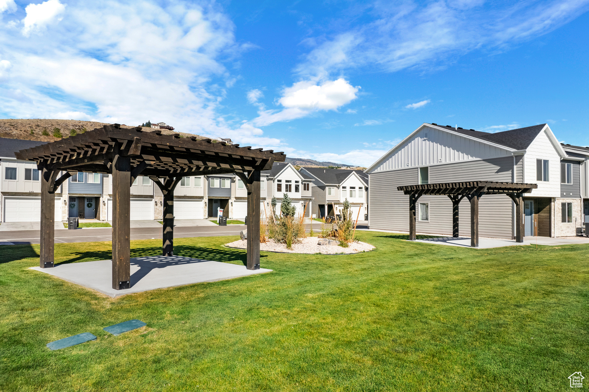 View of property's community featuring a lawn and a pergola